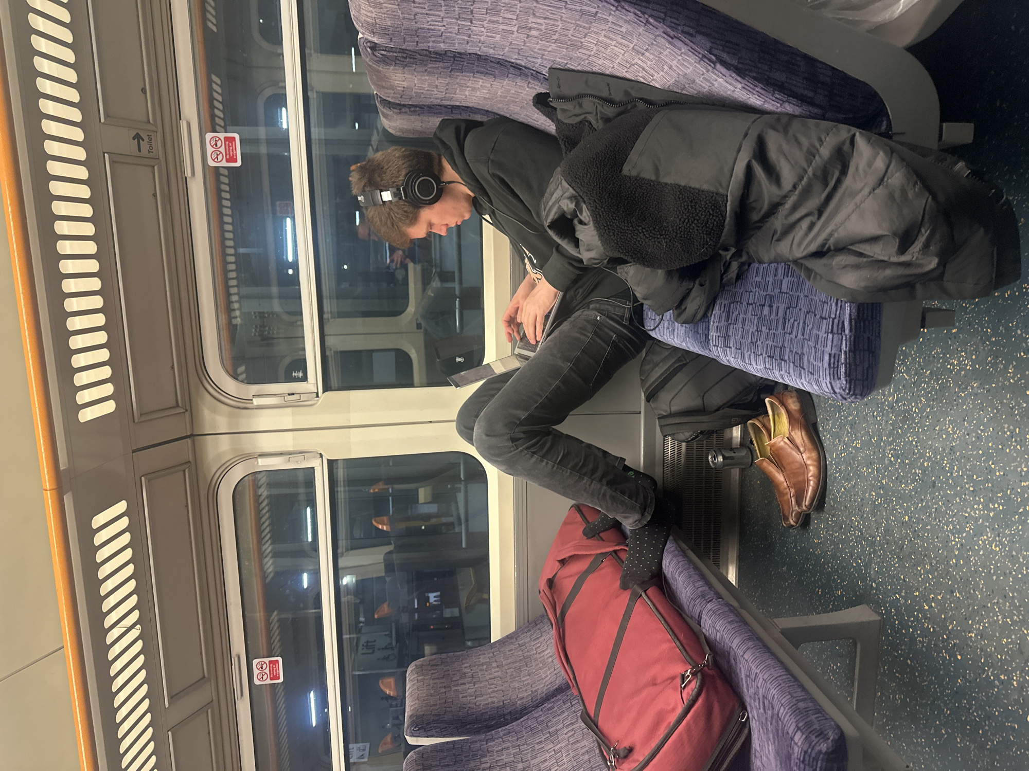 Late night commuter works on laptop during London train journey