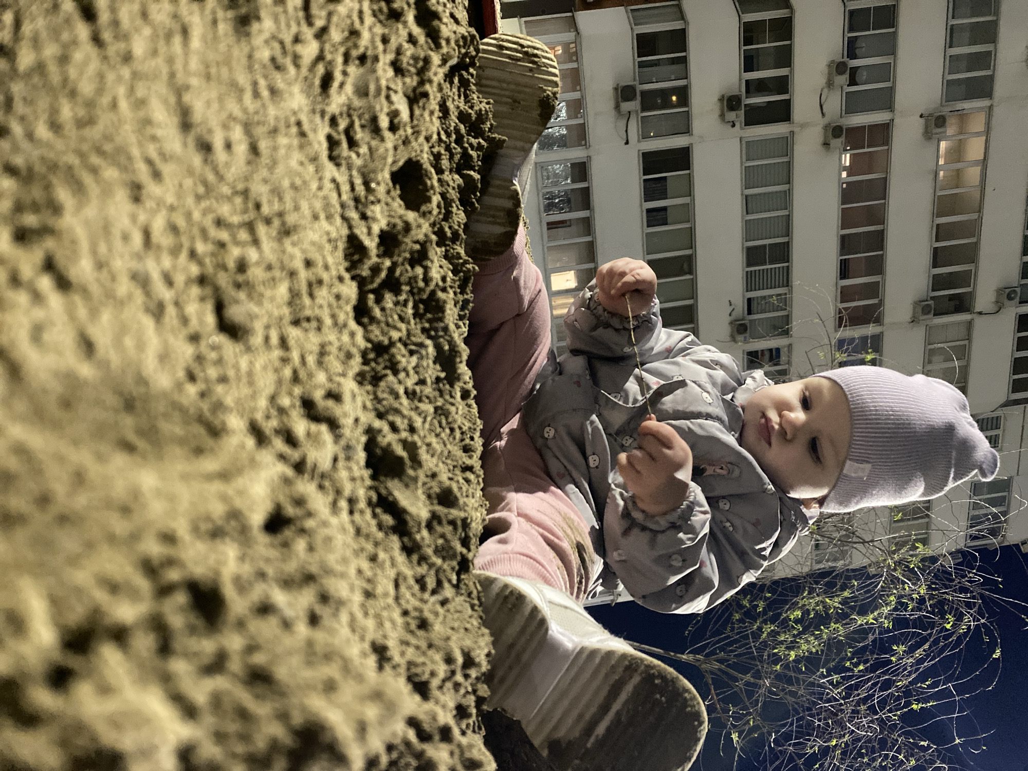 Child plays at urban playground near apartment buildings