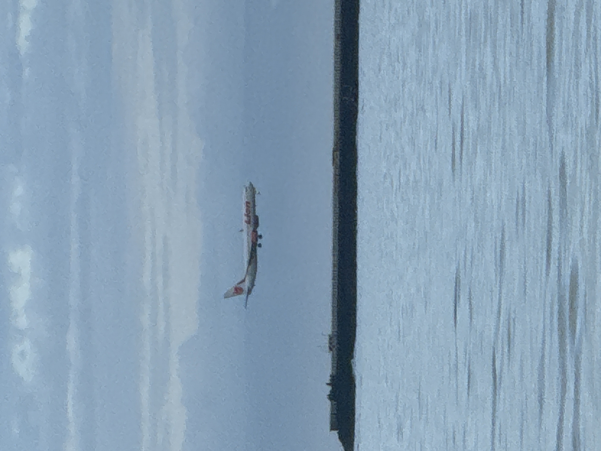 Commercial airplane lands over water near Kuta Selatan beach