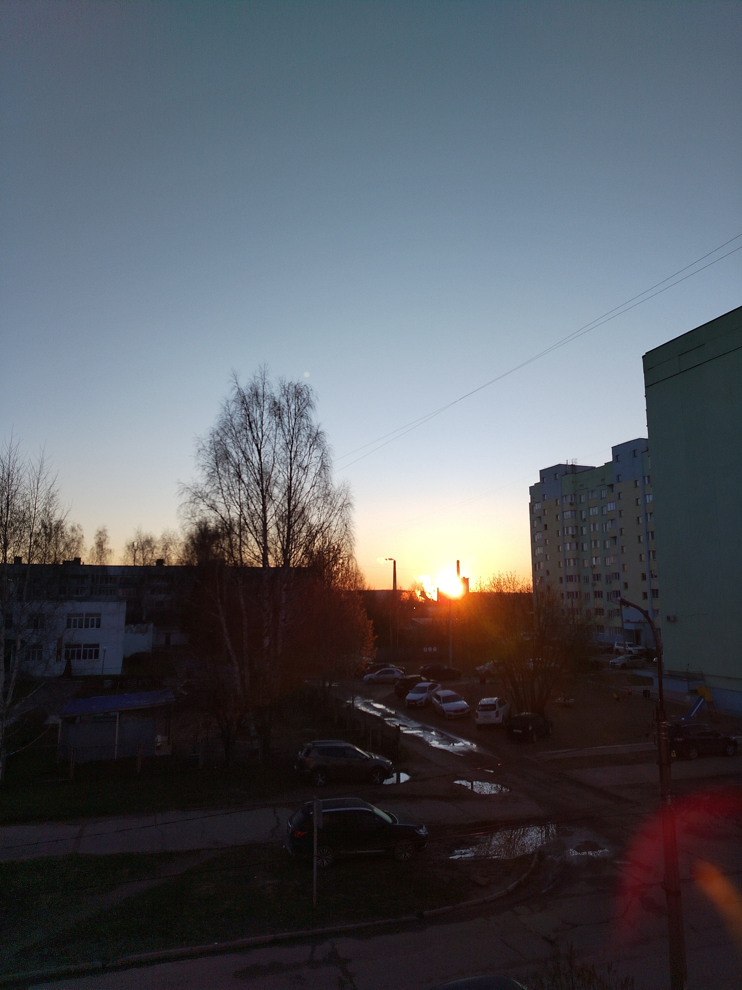 Dawn or dusk sun photographed over residential neighborhood