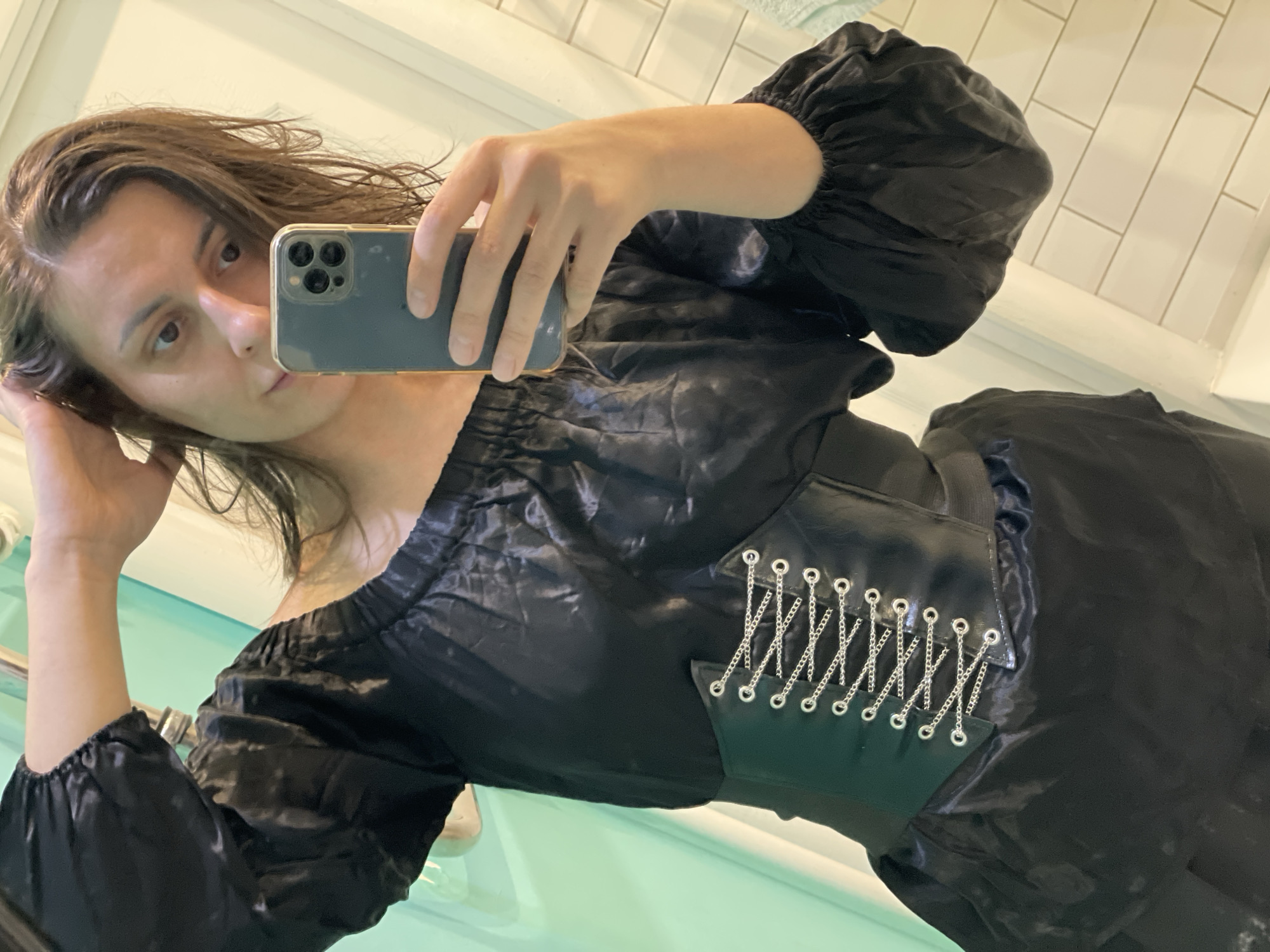 Woman takes bathroom selfie in black off-shoulder dress
