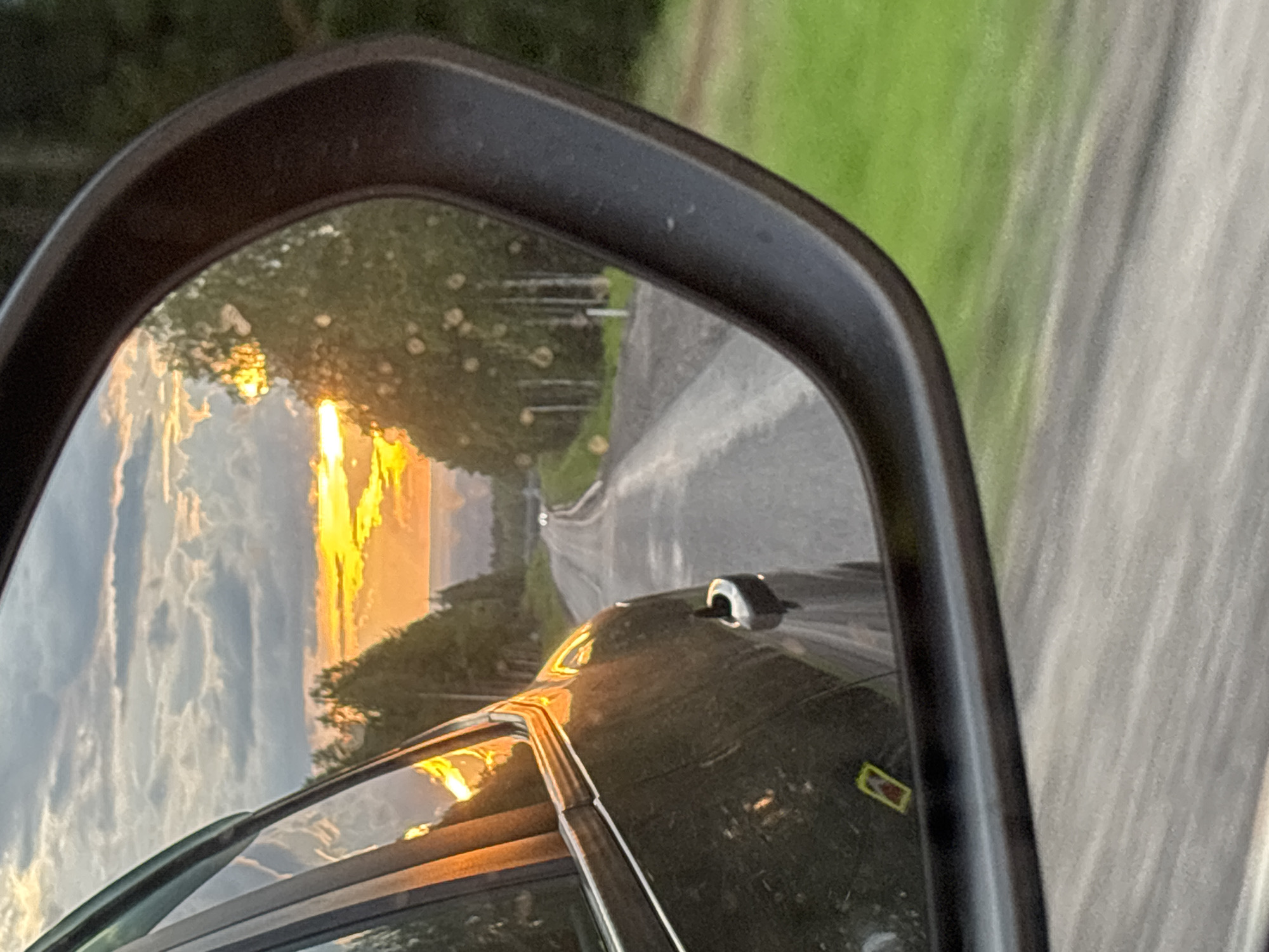 Sunset road view captured in car mirror near Russian quarry