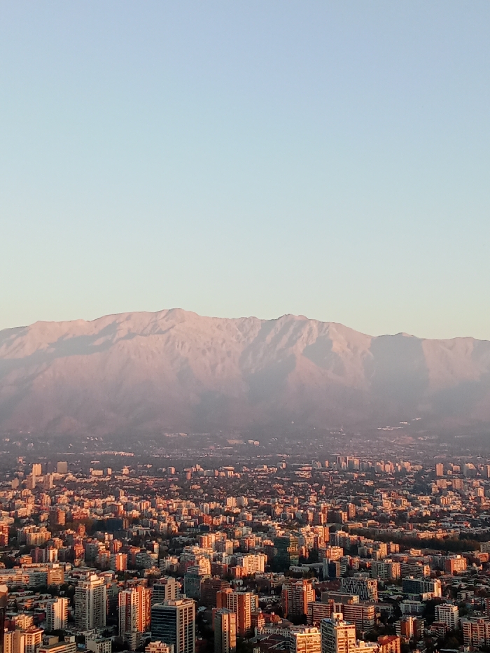 Santiago skyline captured against snow-capped mountains at golden hour