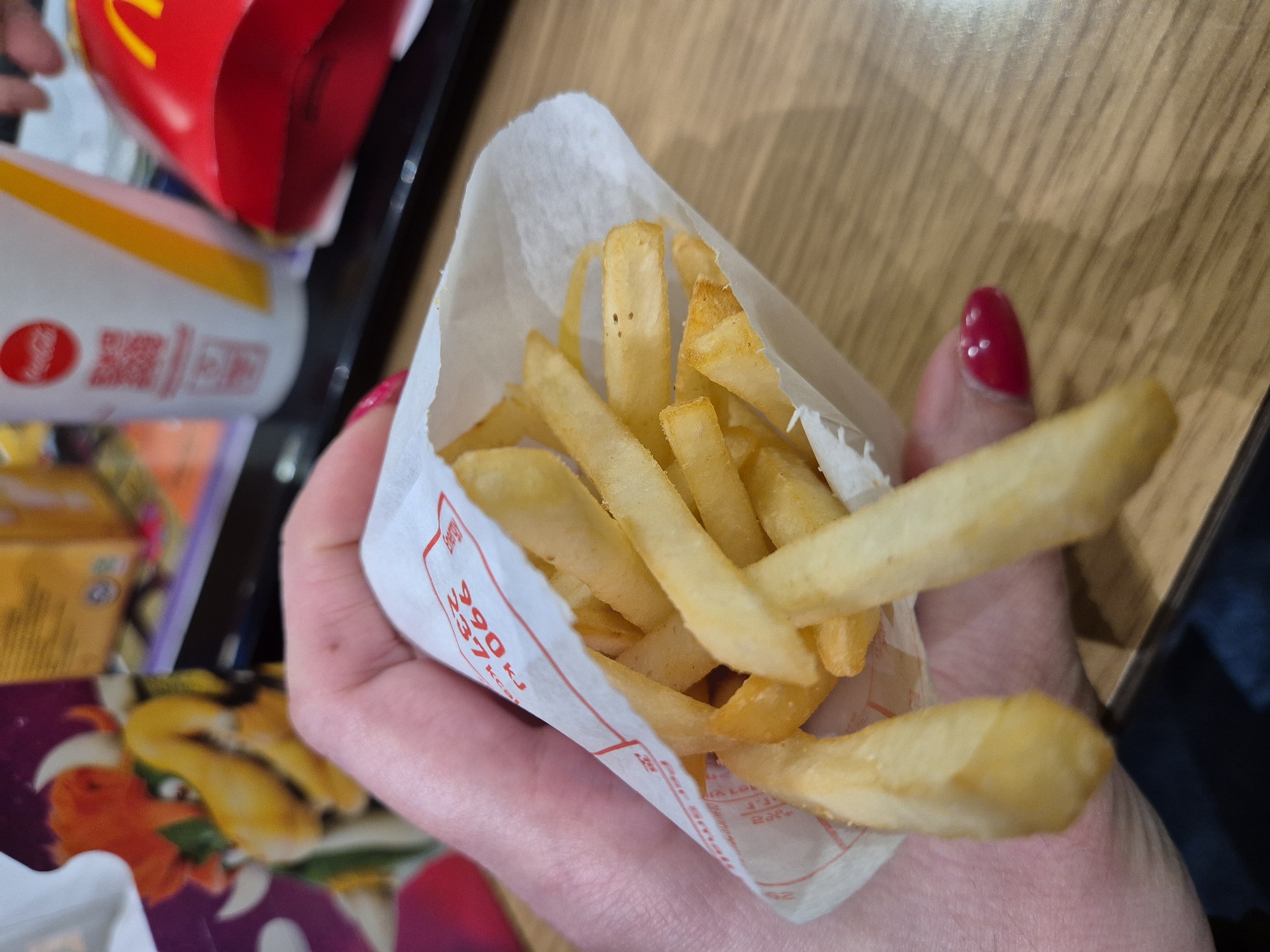 Person enjoys McDonald's fries and tea in West Suffolk