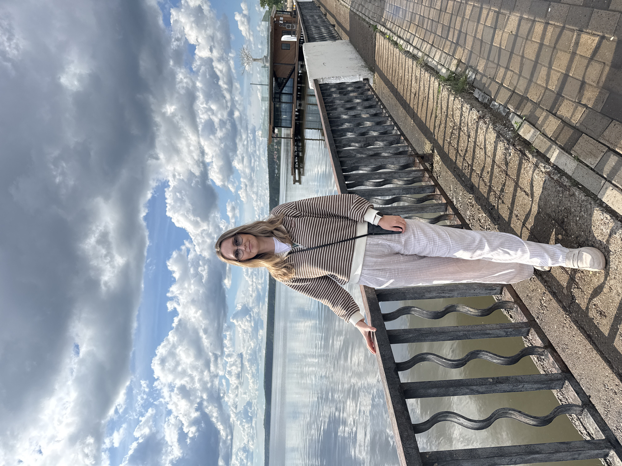 Woman visits military displays along Votkinsk waterfront on cloudy day