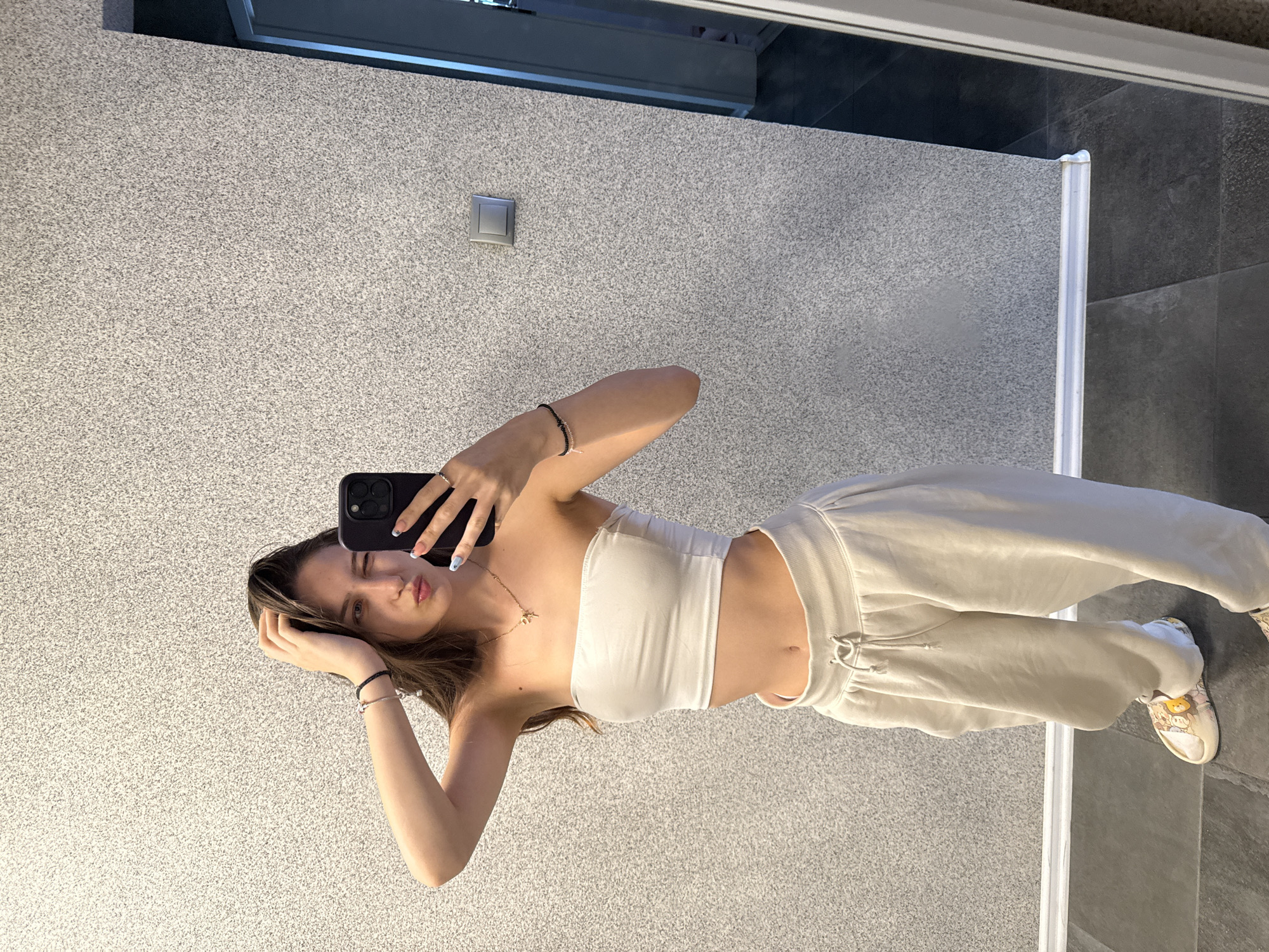 Woman takes mirror selfies, adjusts outfit in Sofia locations