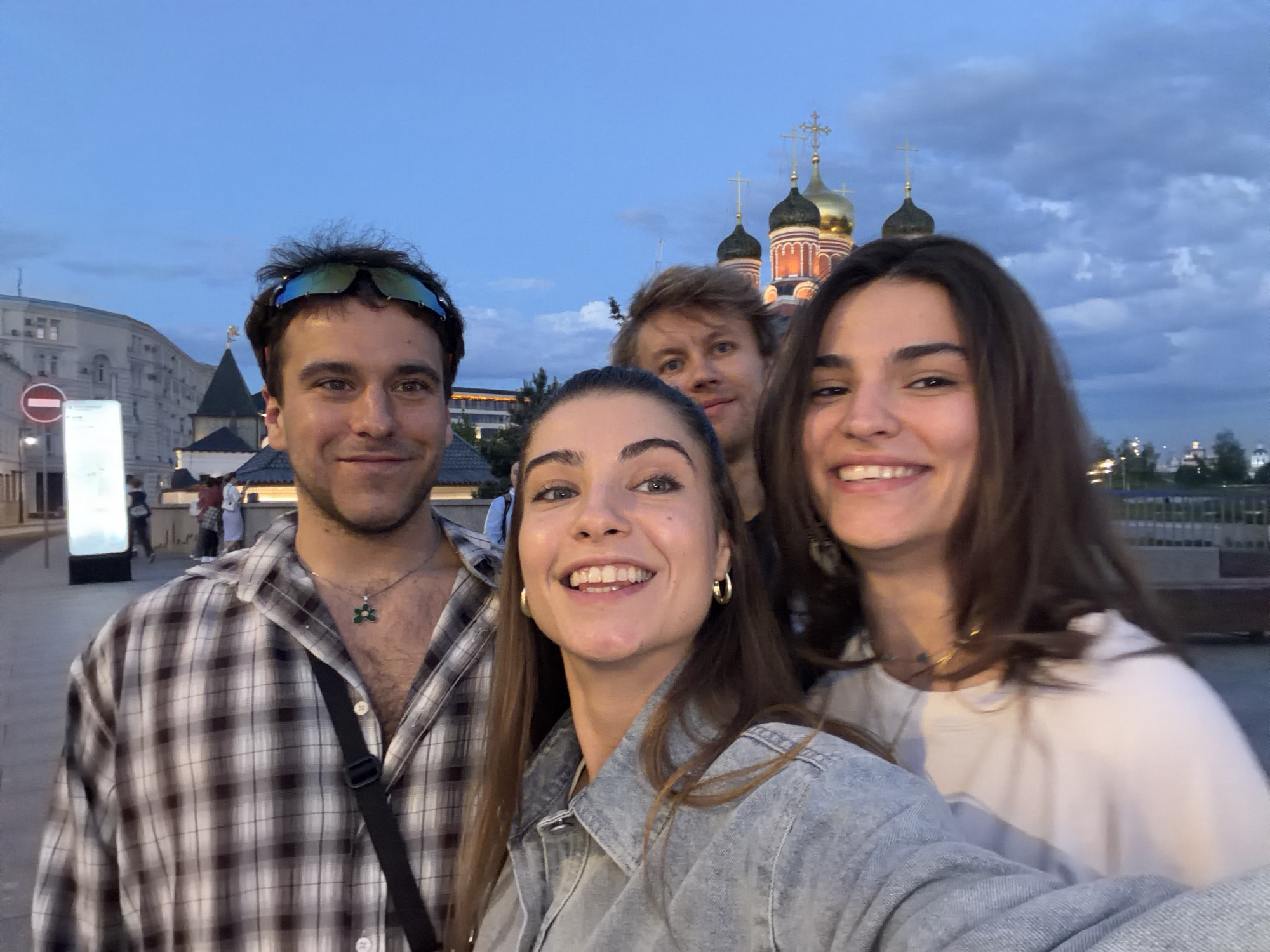Young adults photograph themselves near Moscow memorial at dusk