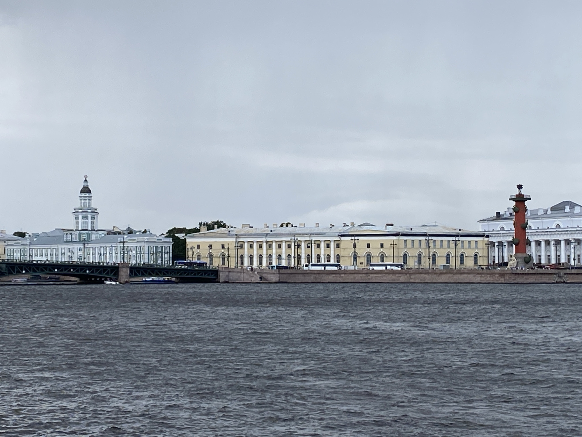 Tour boats navigate a cloudy Neva River past St. Petersburg's waterfront