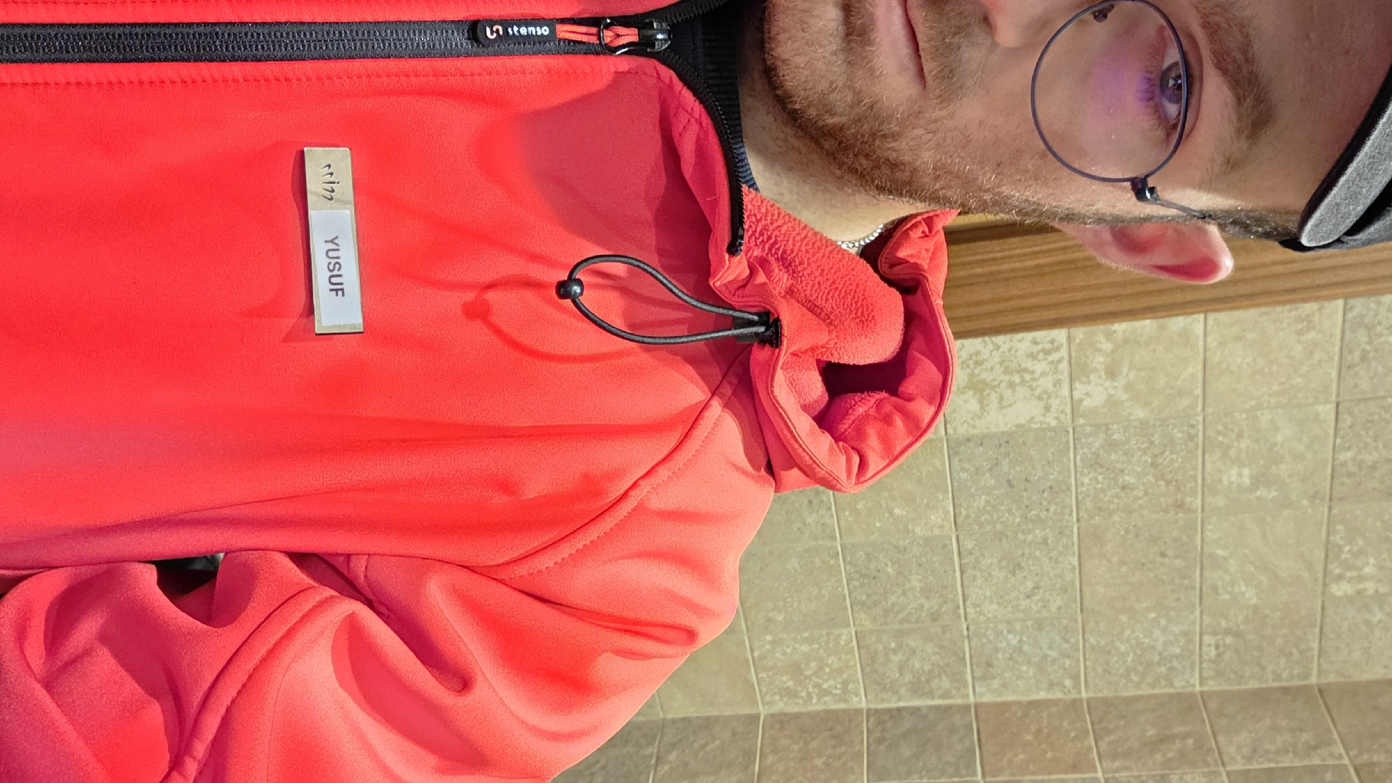 Person in red jacket takes selfie at location