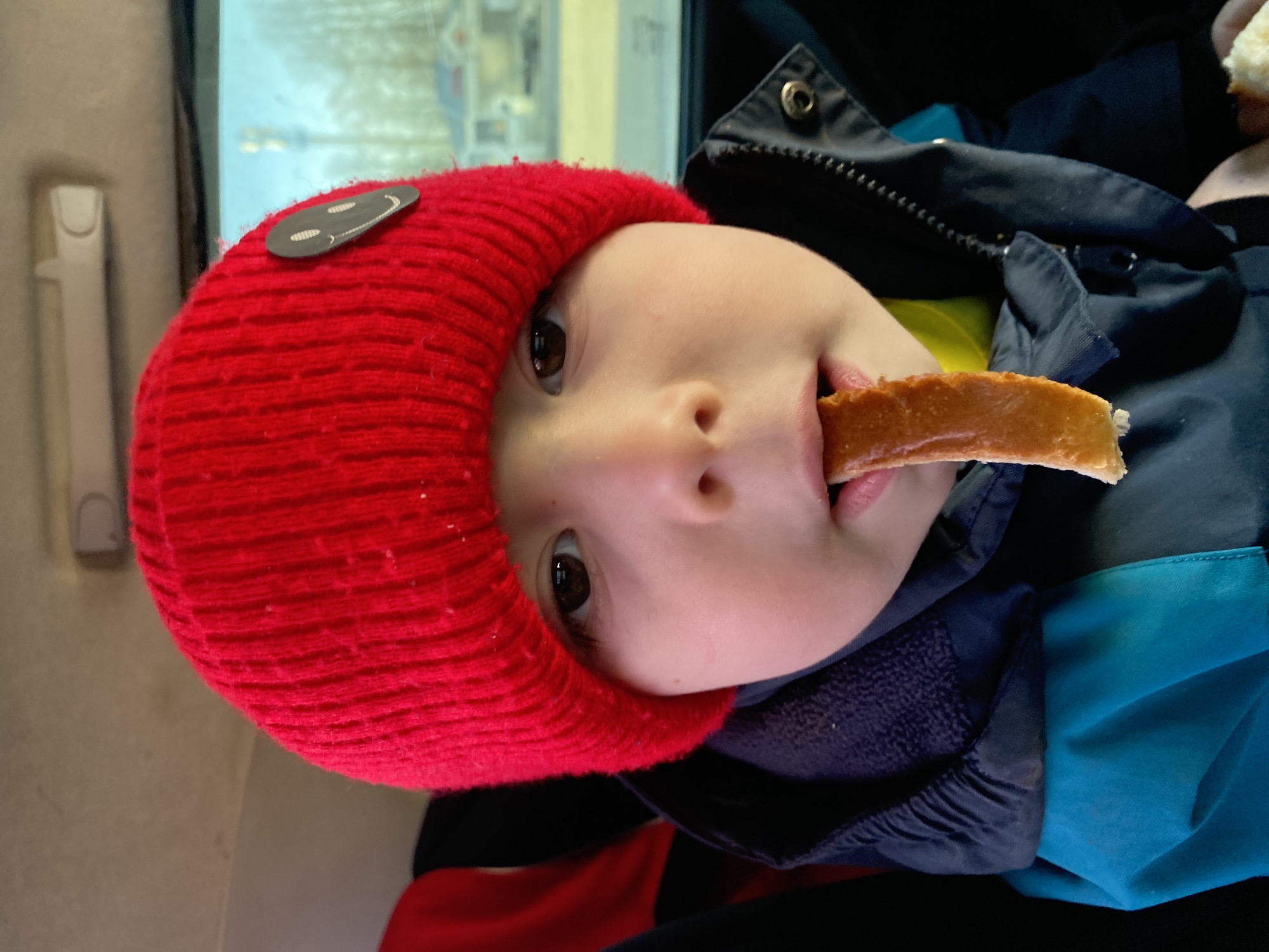 Child eats bread in car during spring drive in Chaykovsky