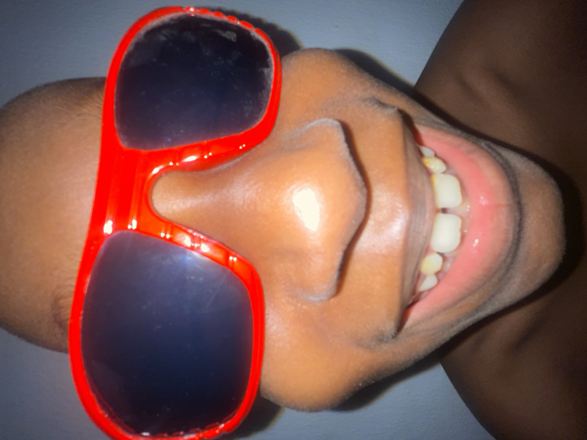 Close-up portrait series with bold sunglasses under red light, Ado