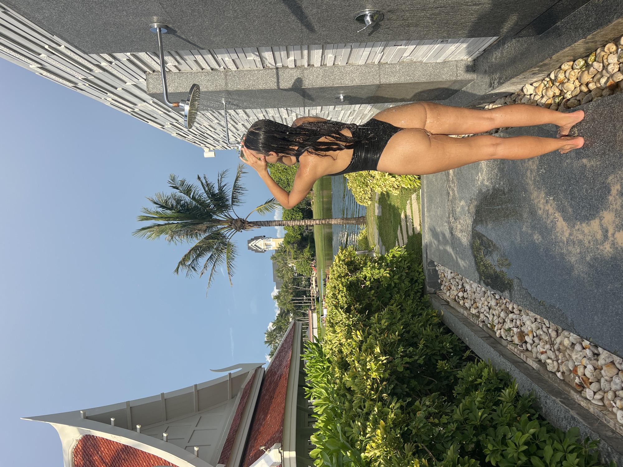 Woman uses outdoor showers at Thai beachfront resort