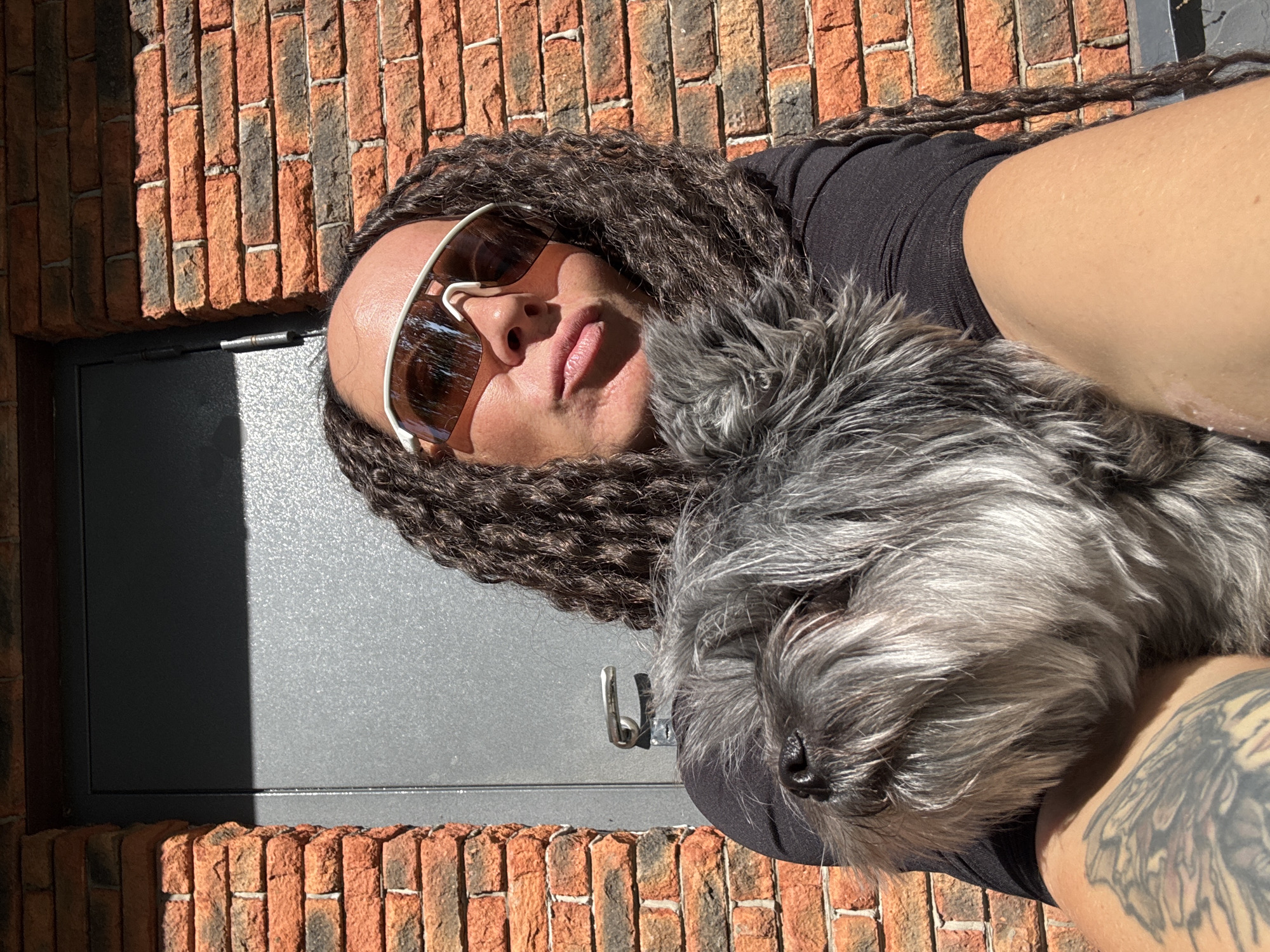 Person with dreadlocks relaxes with dog in Chaikovsky park