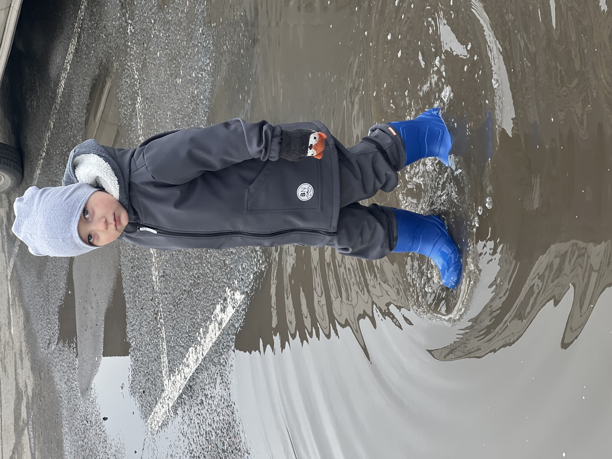 Child plays in puddles during morning outing in Mytishchi