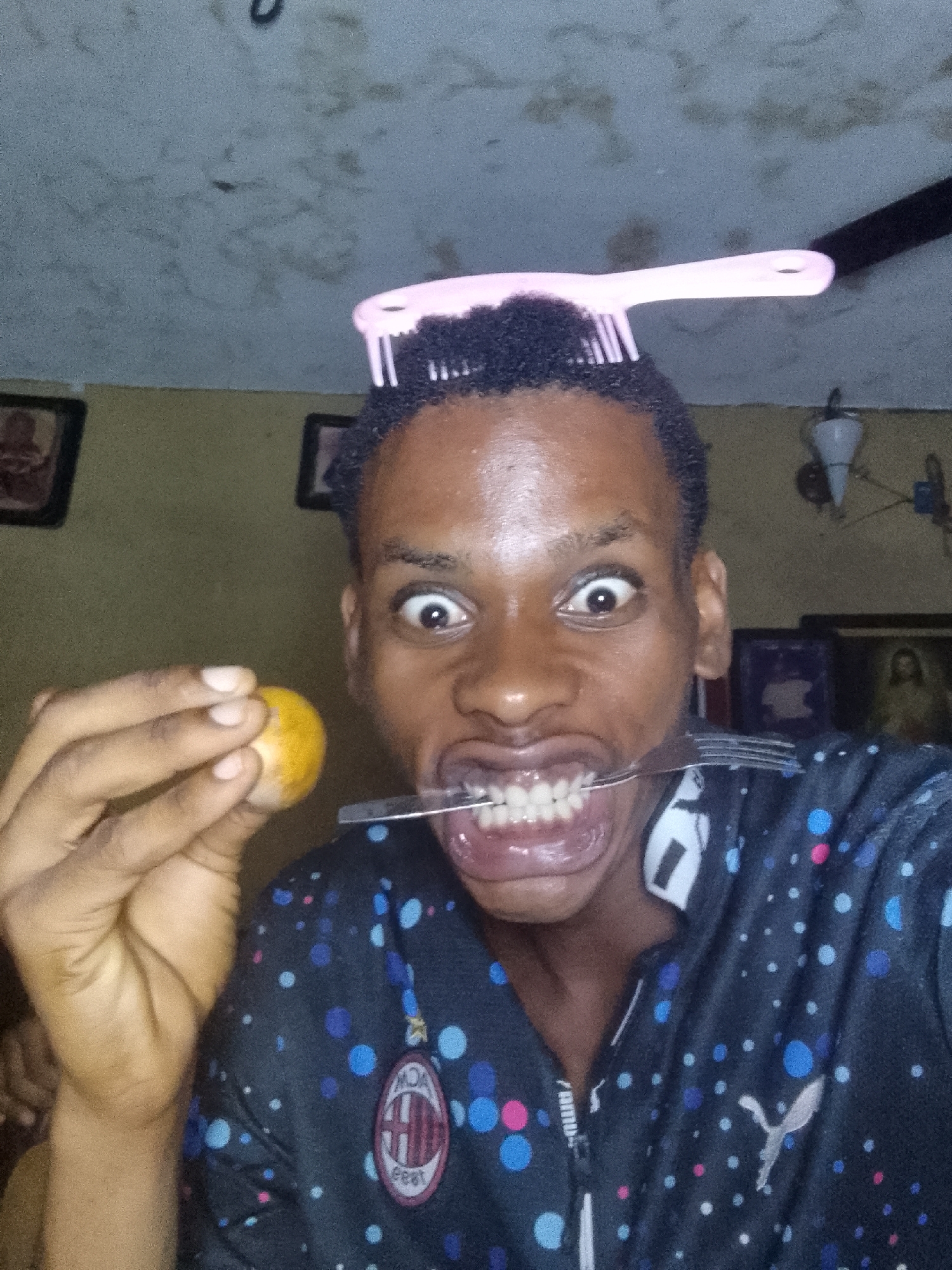 Person makes silly faces with objects, pink comb present