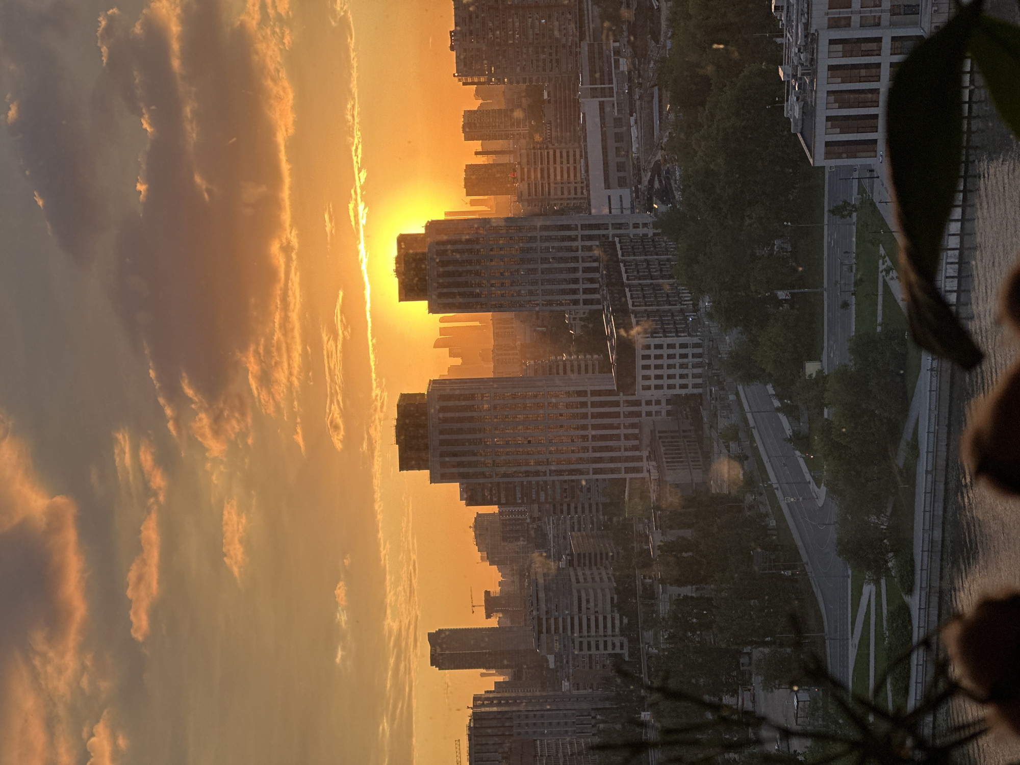 Moscow skyline glows warm as the sun sets behind downtown buildings.