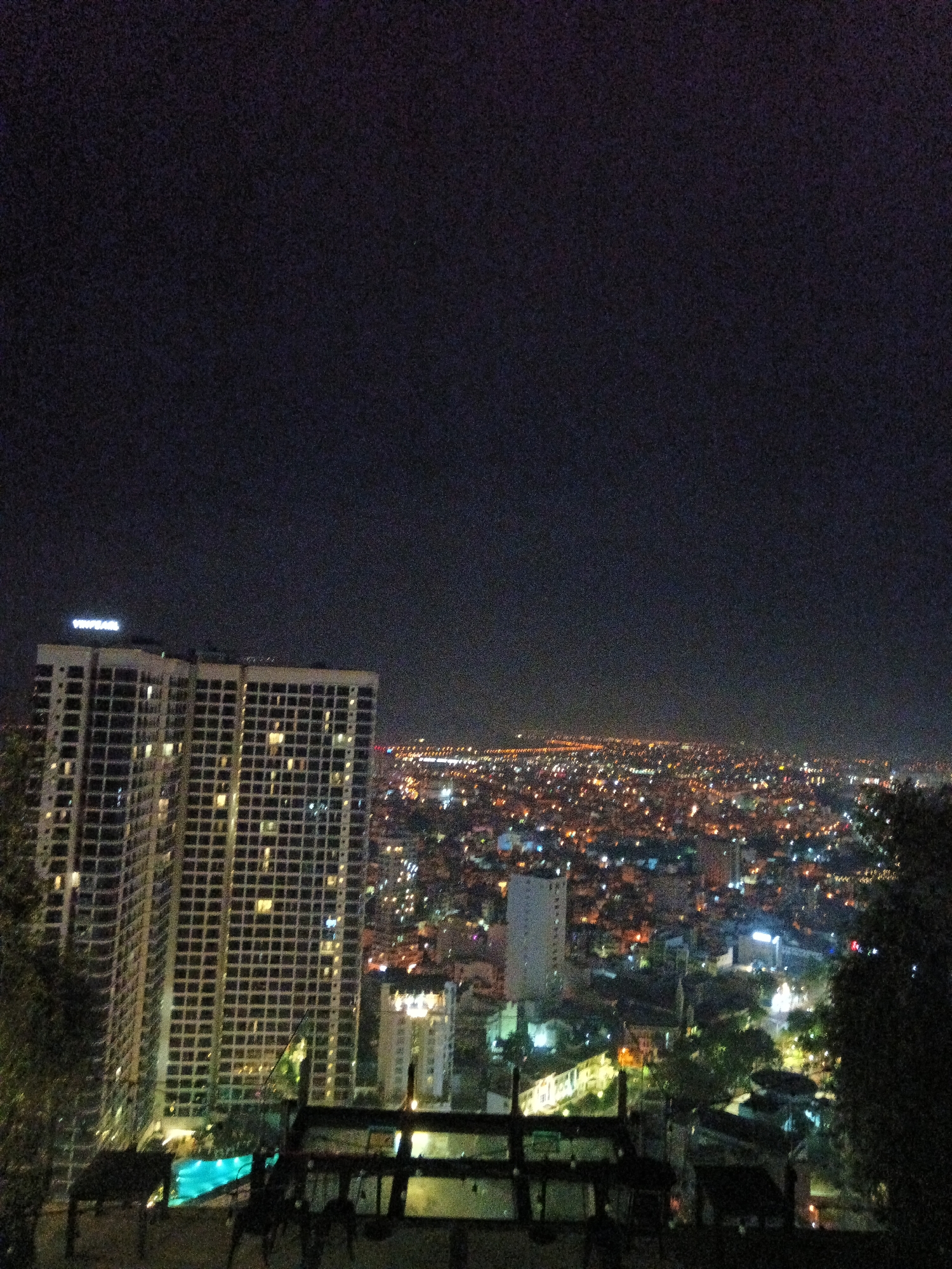 Tourist visits Nha Trang rooftop bar, documents nighttime cityscape views