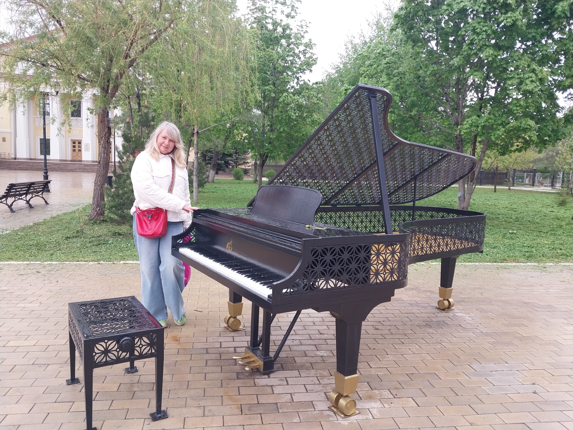 Woman poses beside public piano in Orenburg, Russia