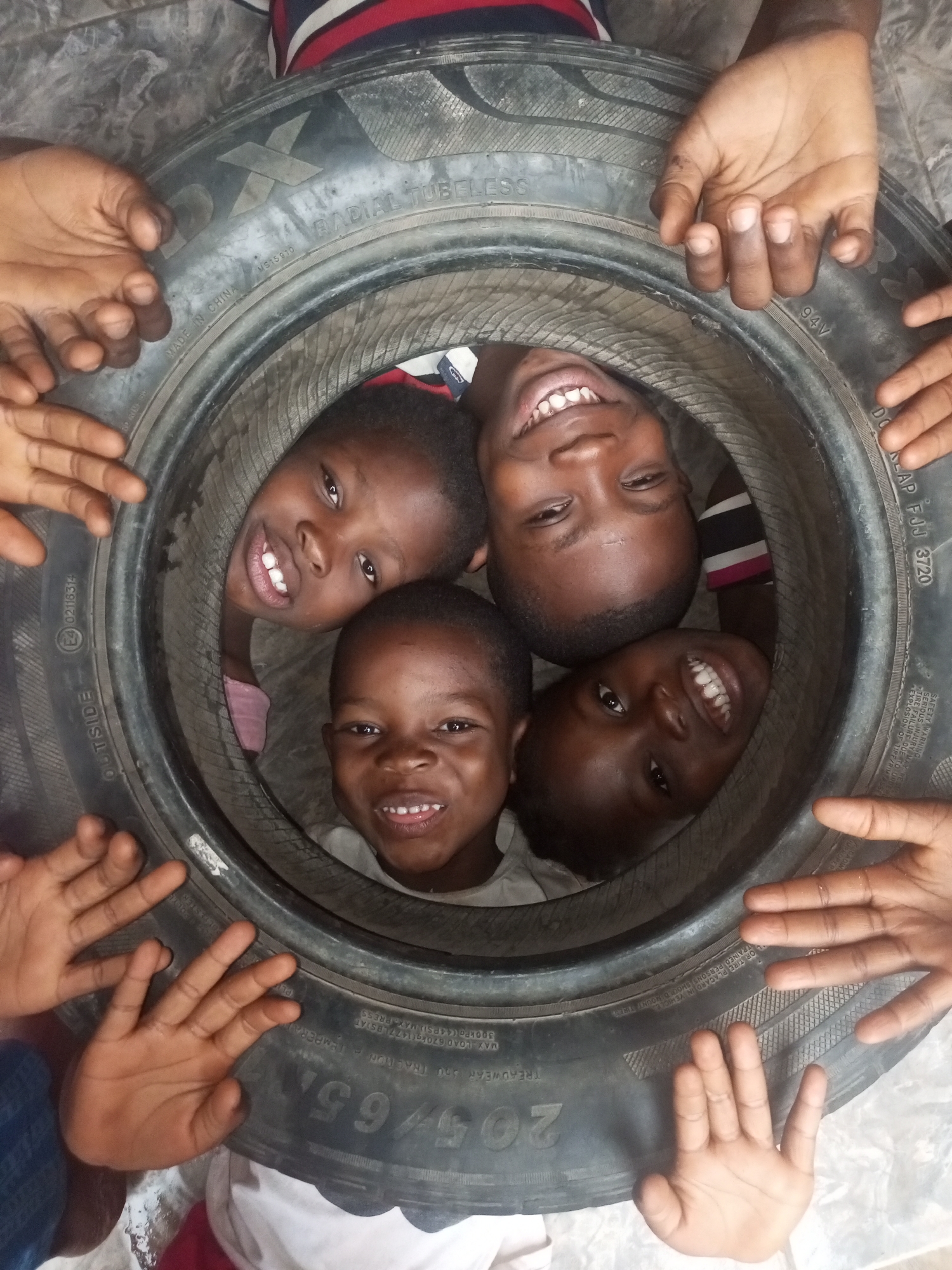 Children play inside tire in Tempure, Nigeria