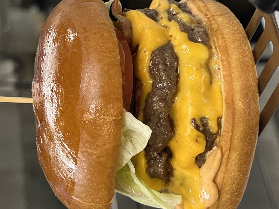 Double cheeseburger preparation documented in Budva, Montenegro