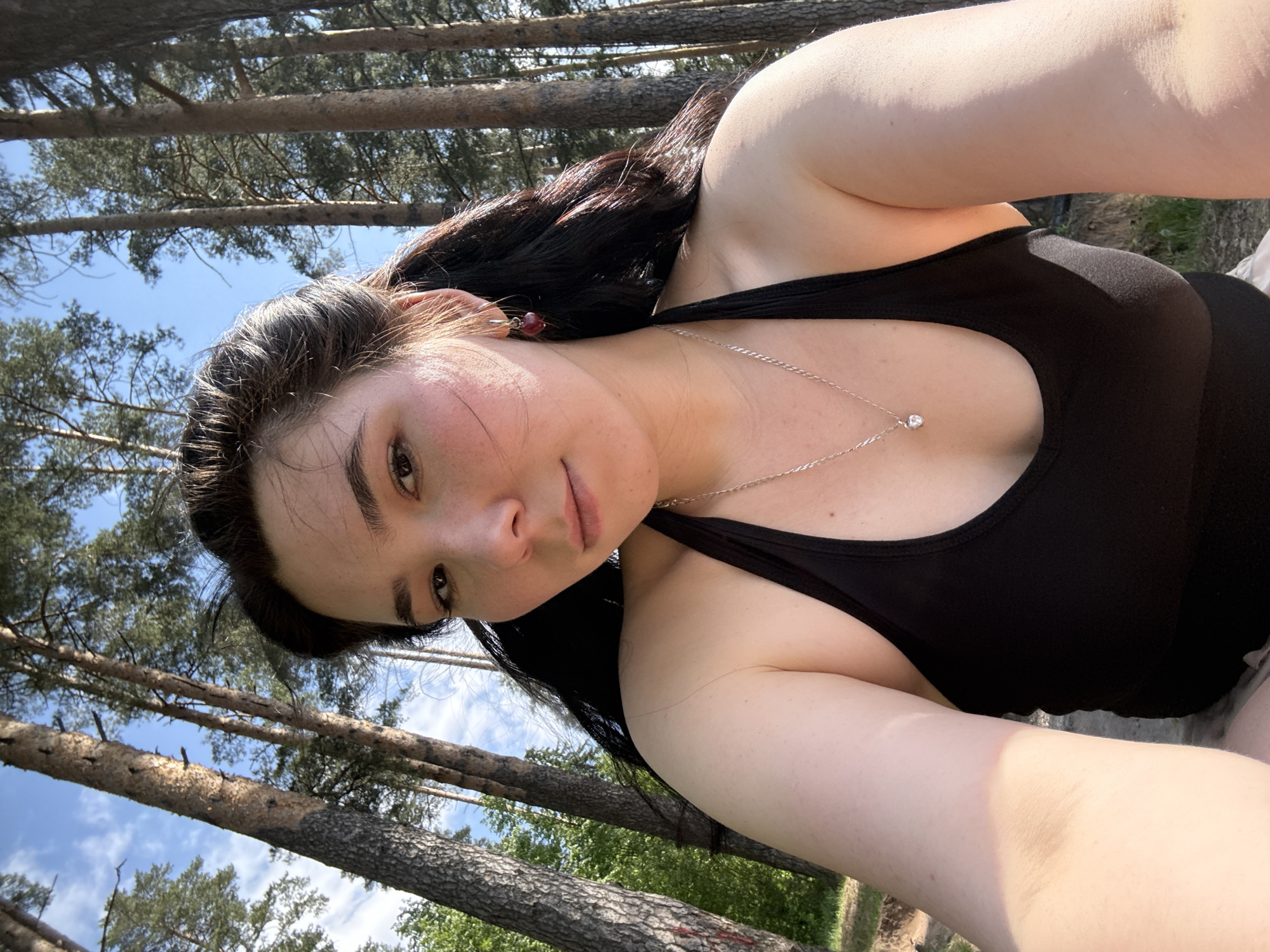 Woman takes selfies by water in Izhevsk forest setting