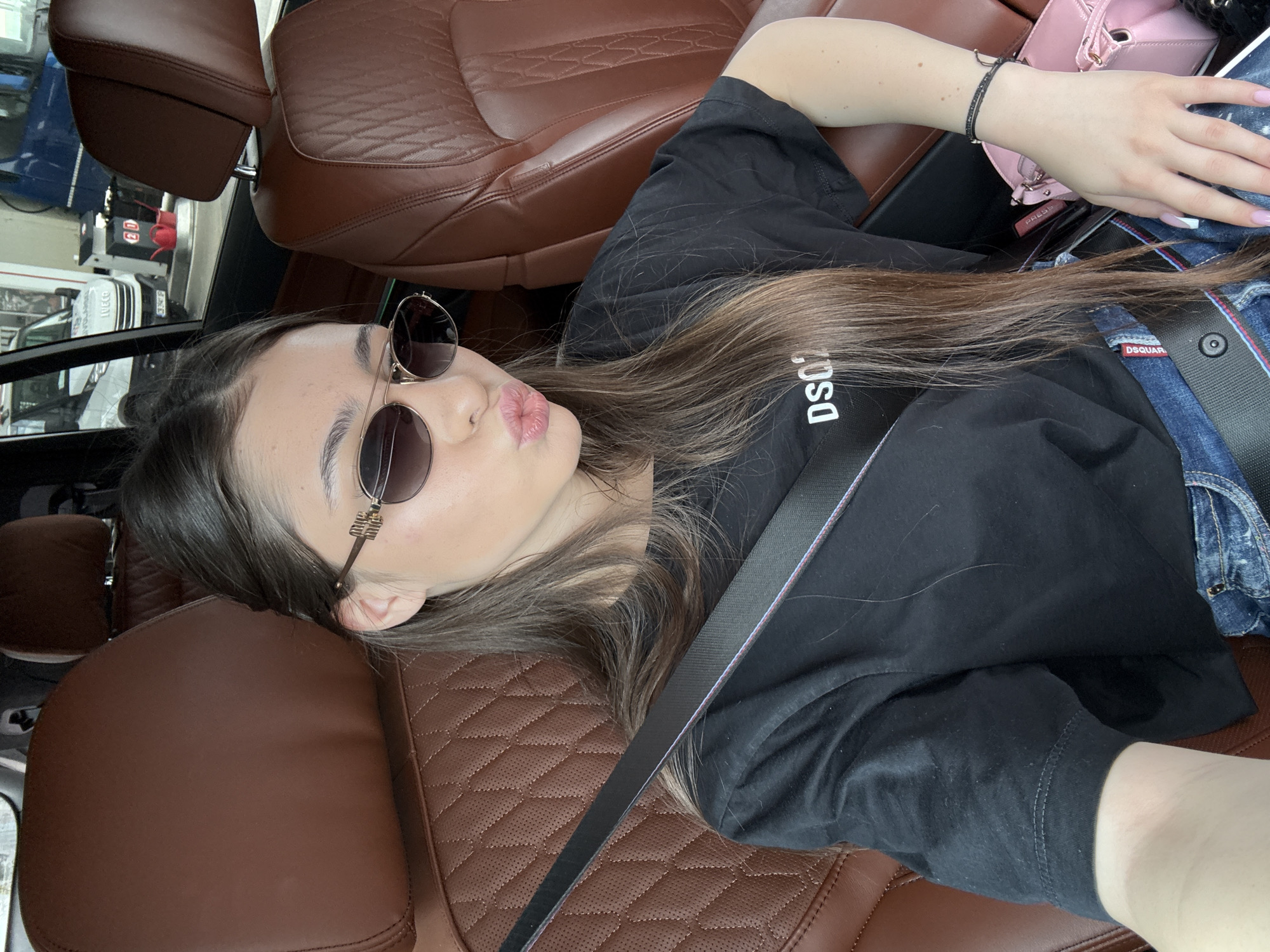 Woman rests in passenger seat wearing designer clothing in Bulgaria