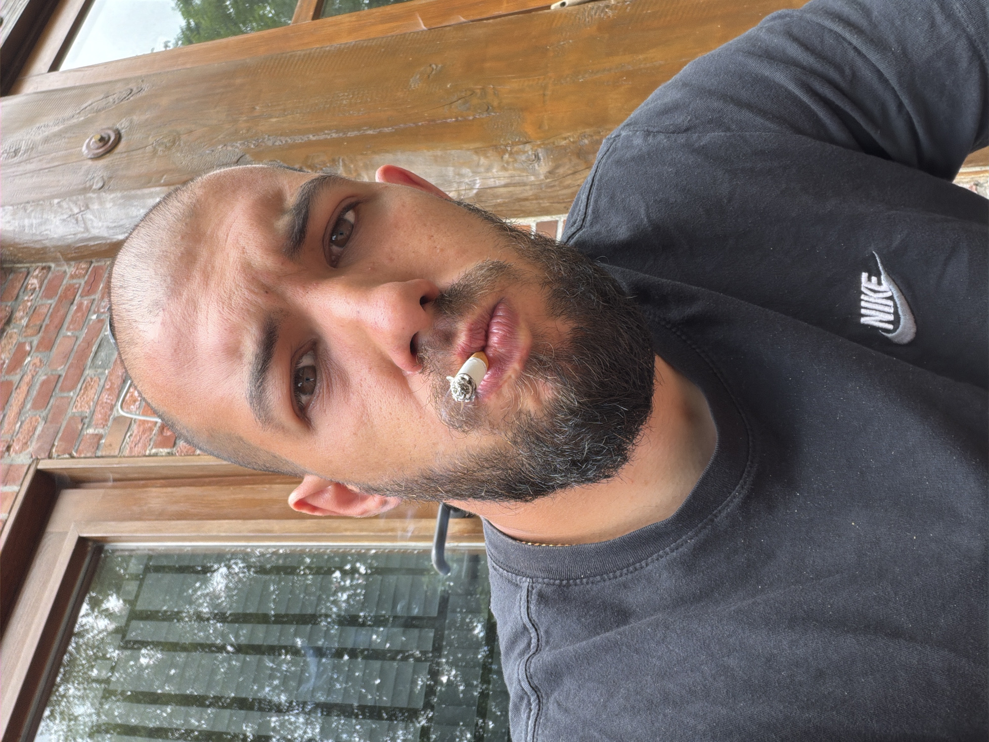 Man smoking outside wooden building in Ovelgönne Saturday morning