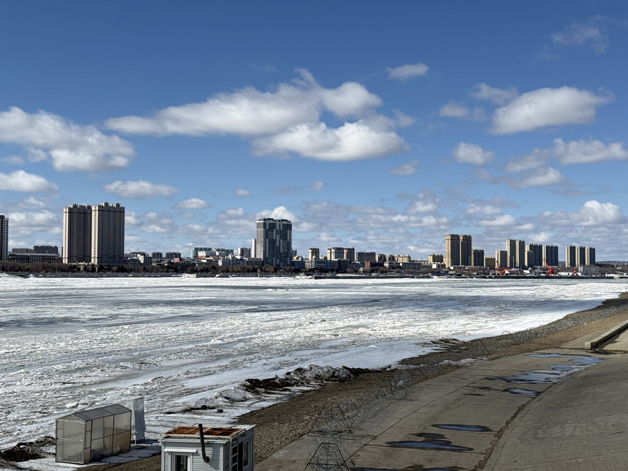 City riverfront scenes show partially frozen waterway, urban skyline