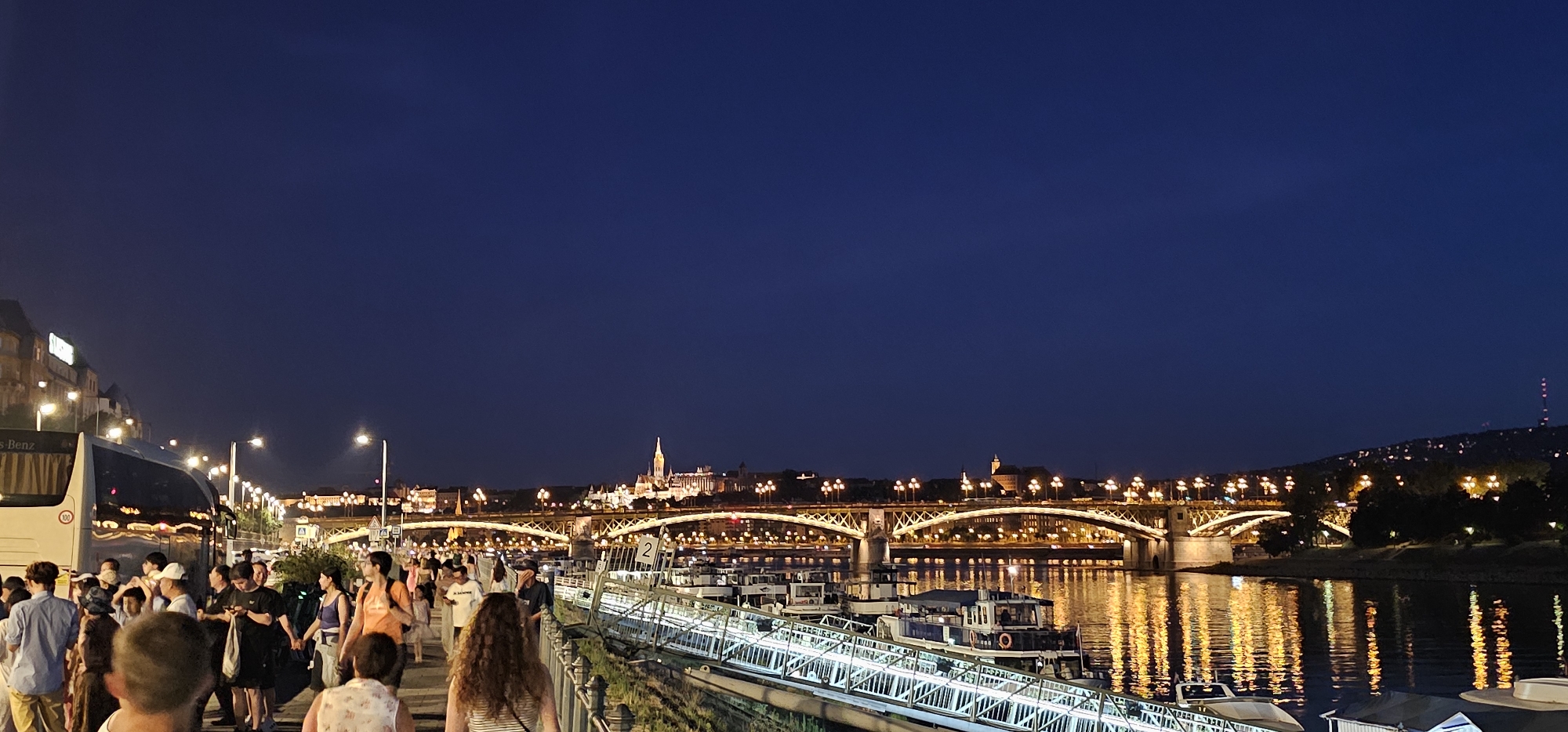 Budapest's Danube promenade glows under a clear night sky.