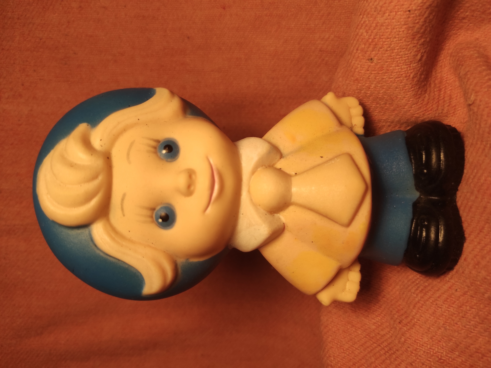 Vintage toy figures photographed against fabric backgrounds in Chernihiv