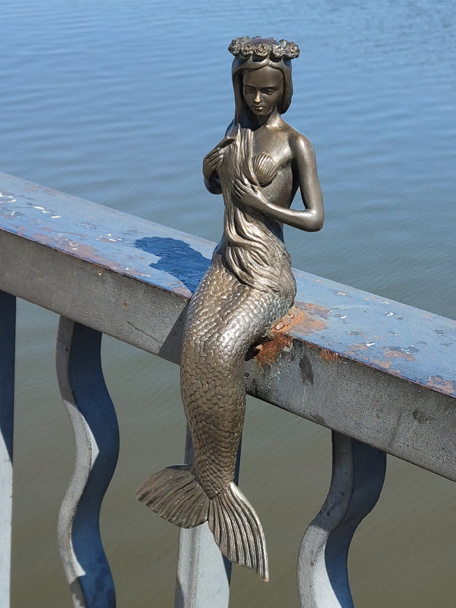 Waterfront area witnesses document mermaid statue, pizza poses, casual moments