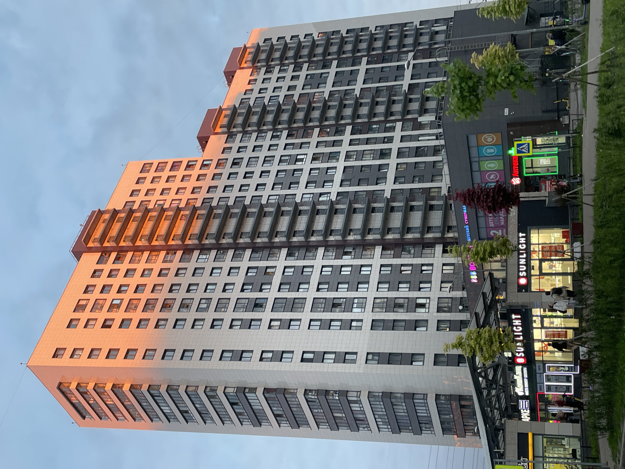 Evening cityscape captured showing modern residential buildings at sunset