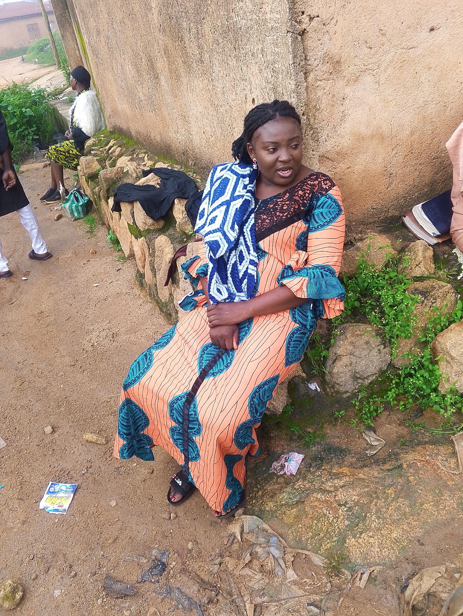 Village gathering, people resting and tending to a child outdoors