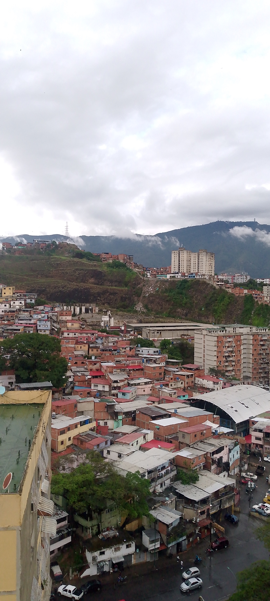 Caracas residents document hillside neighborhoods during overcast June evening