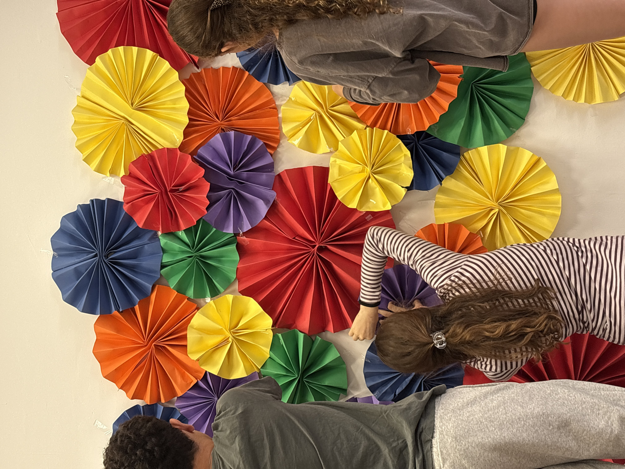Youth decorate indoor space with colorful fans in Tel Aviv
