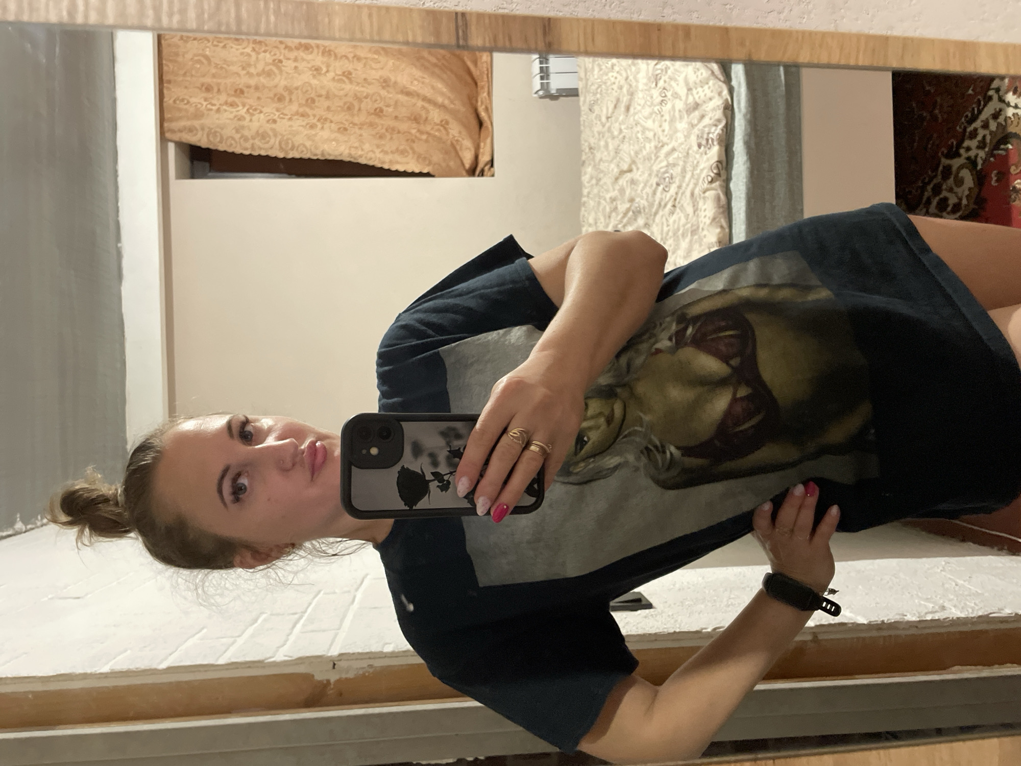 Indoor mirror selfie in Zarichne, dark graphic tee, hair up.