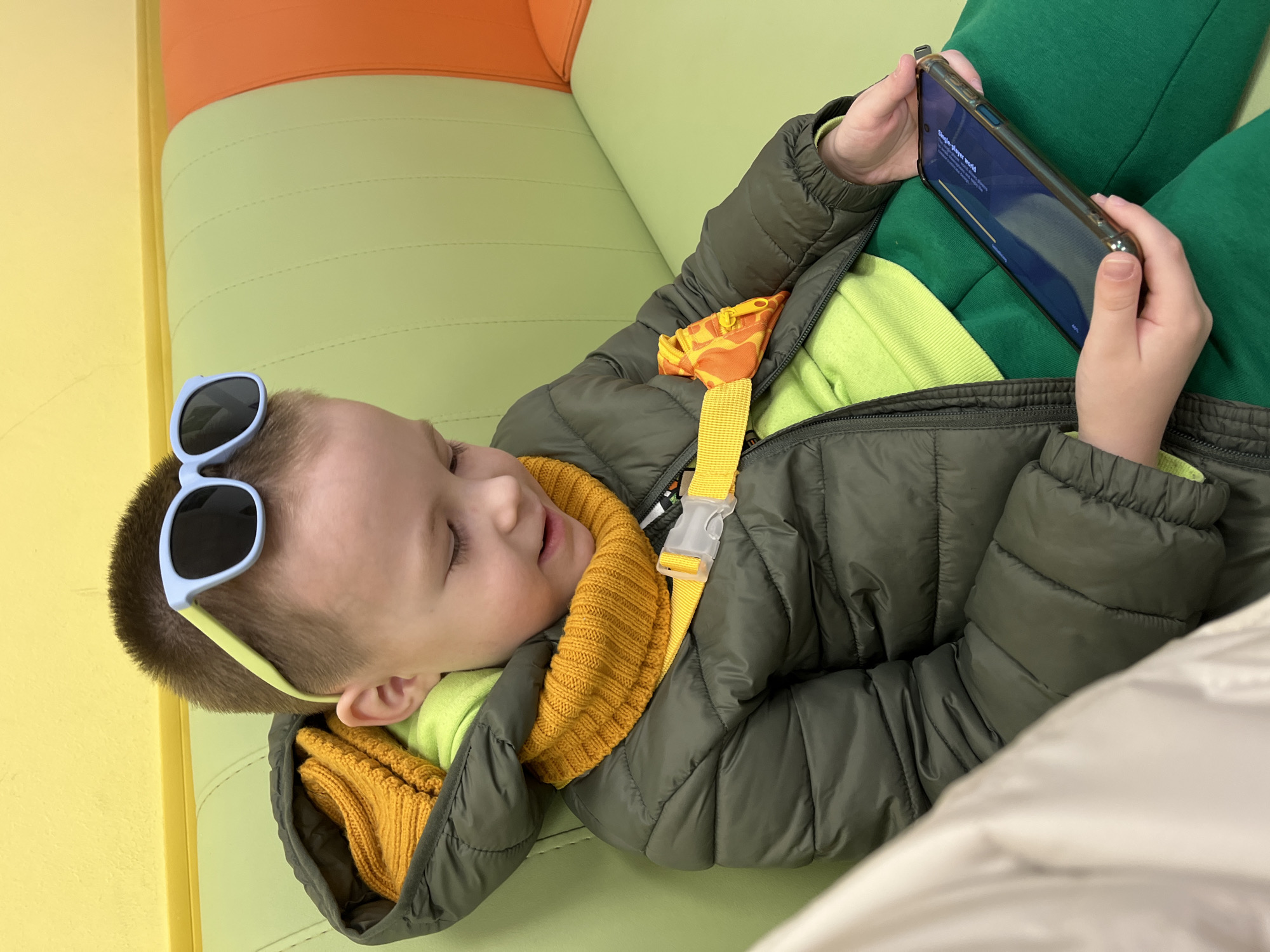 Child rests on colorful cushion in Usman, Russia