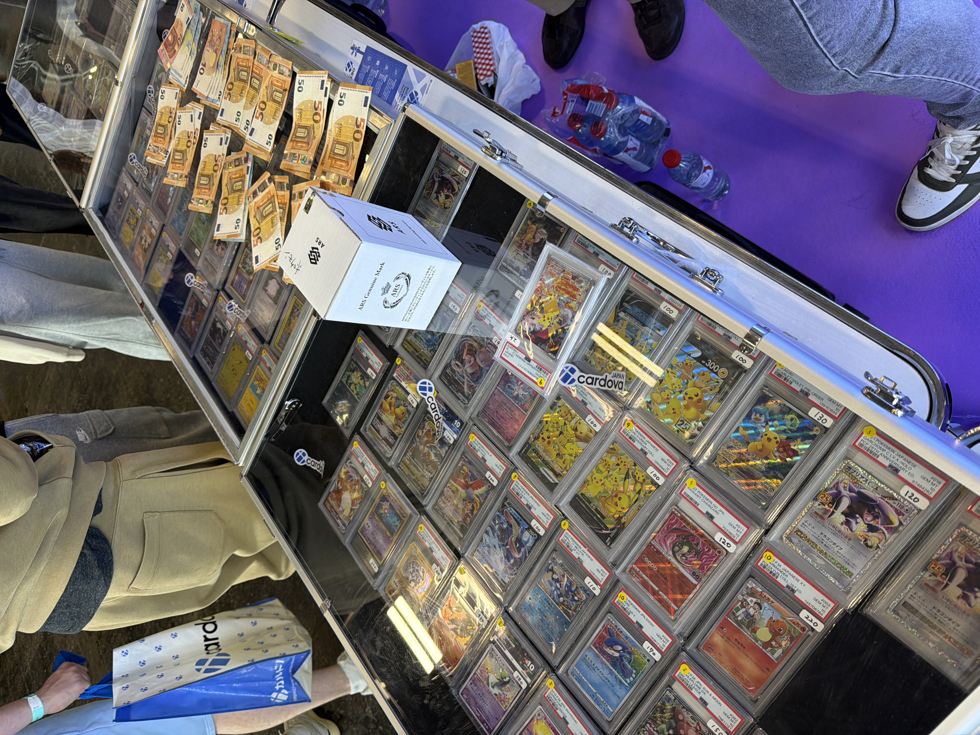 Graded Pokemon cards displayed with Euro cash in Paris