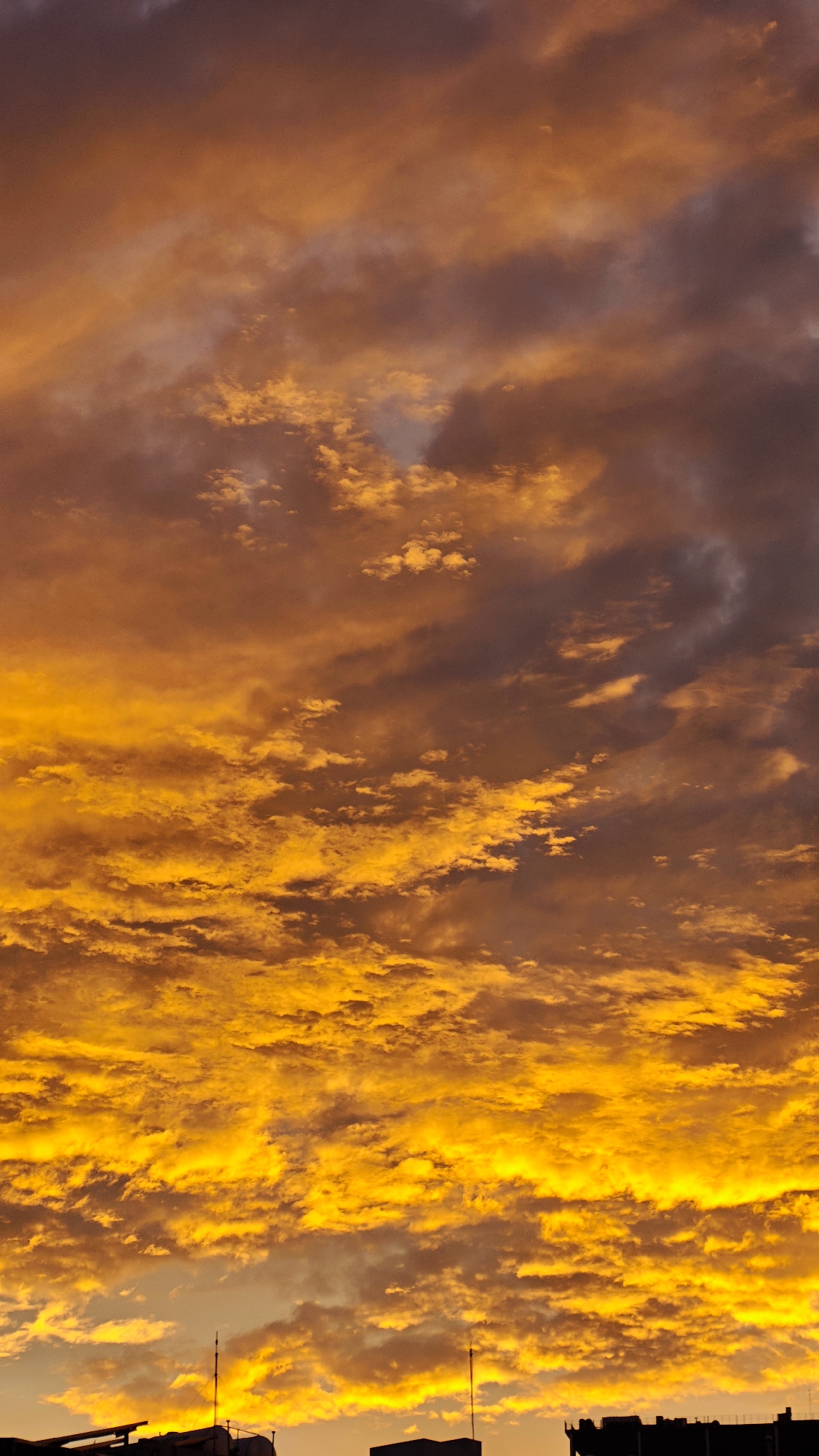 Hanoi street life glows under a fiery evening sky