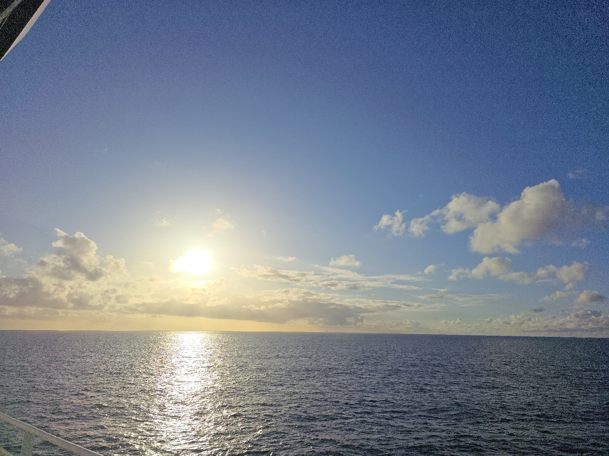 Calm seas and offshore oil platform observed under evening sky