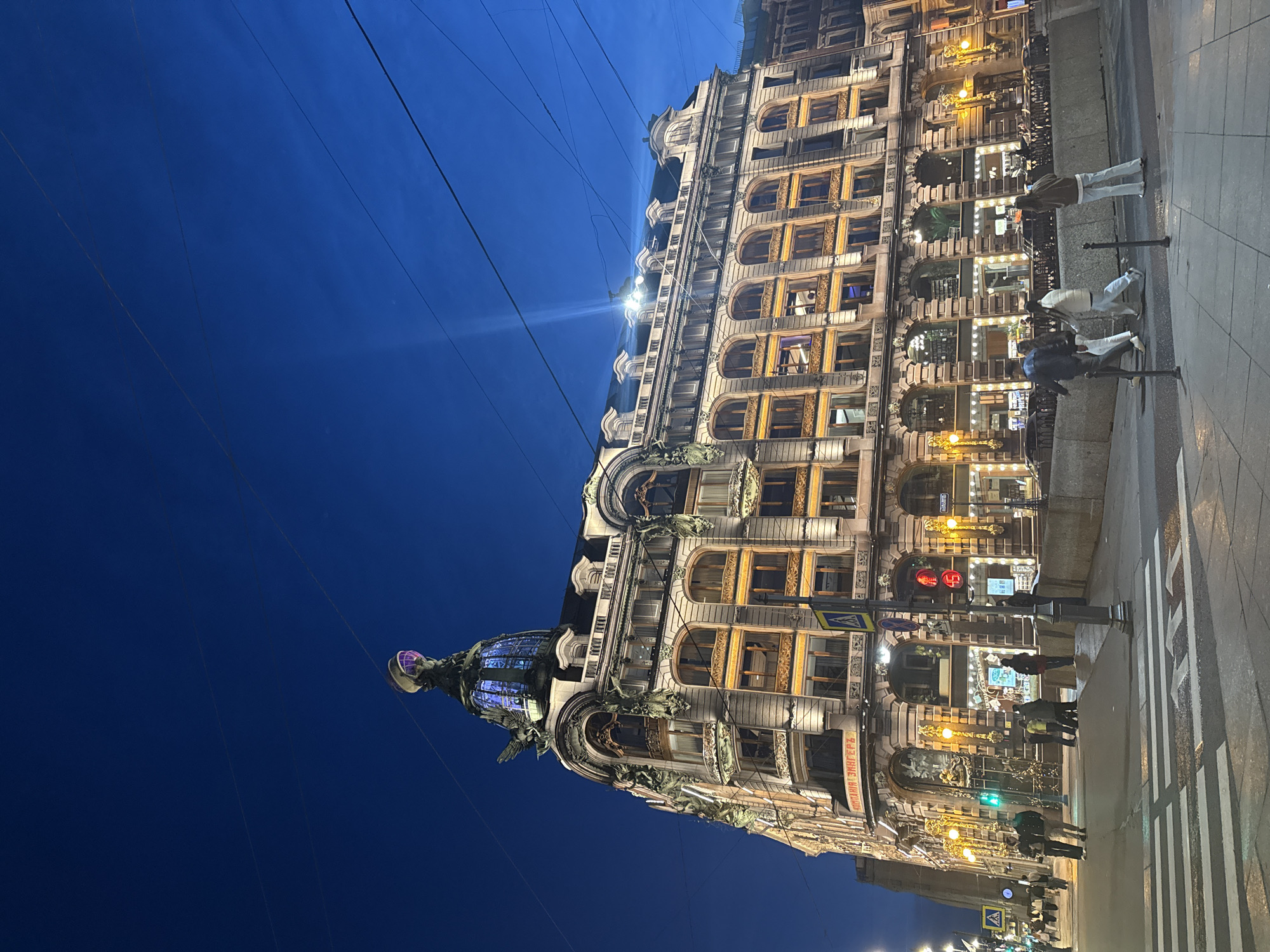 Evening street life unfolds across historic Saint Petersburg landmarks