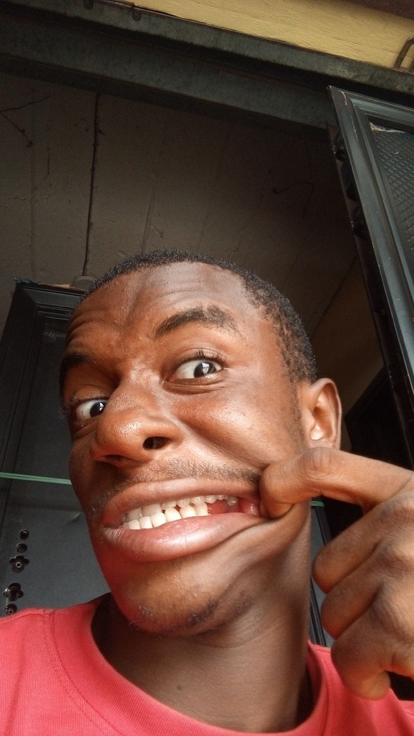 Young man makes playful faces for camera in Nkpor