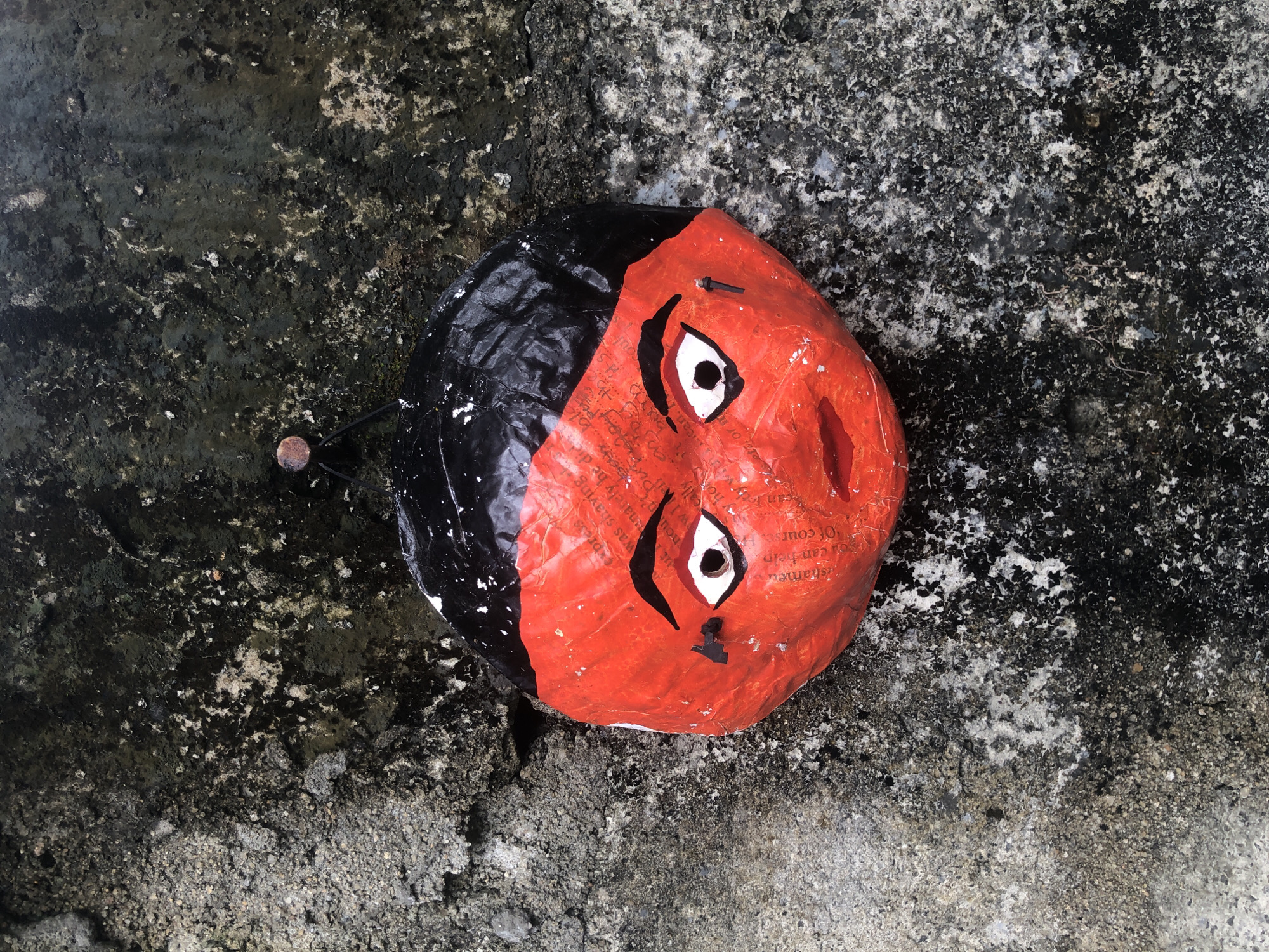 Handmade papier-mâché mask photographed on ground in Kabalana, Sri Lanka