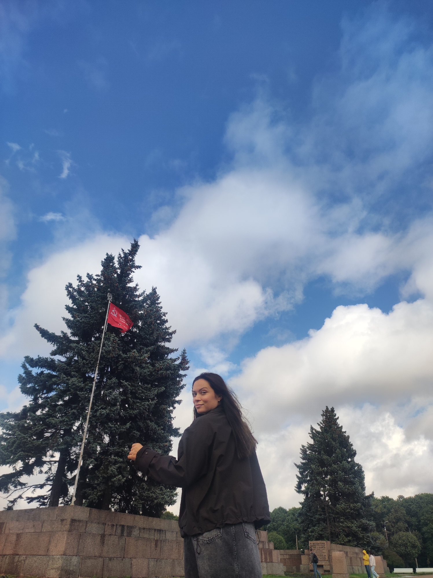 Sunny park moments in Saint Petersburg, arms wide under blue skies