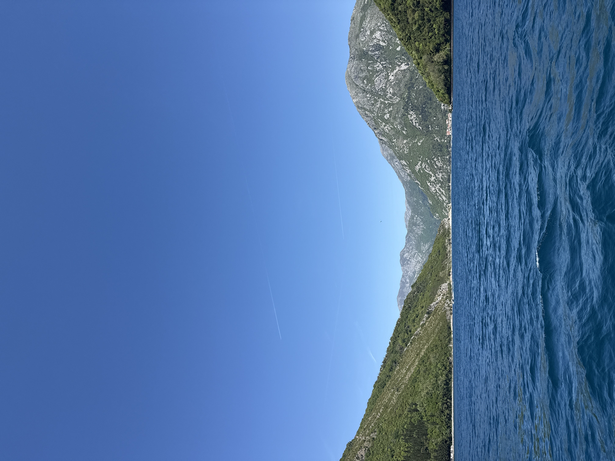 Boat travels scenic waters near Lepetane, Montenegro coastline