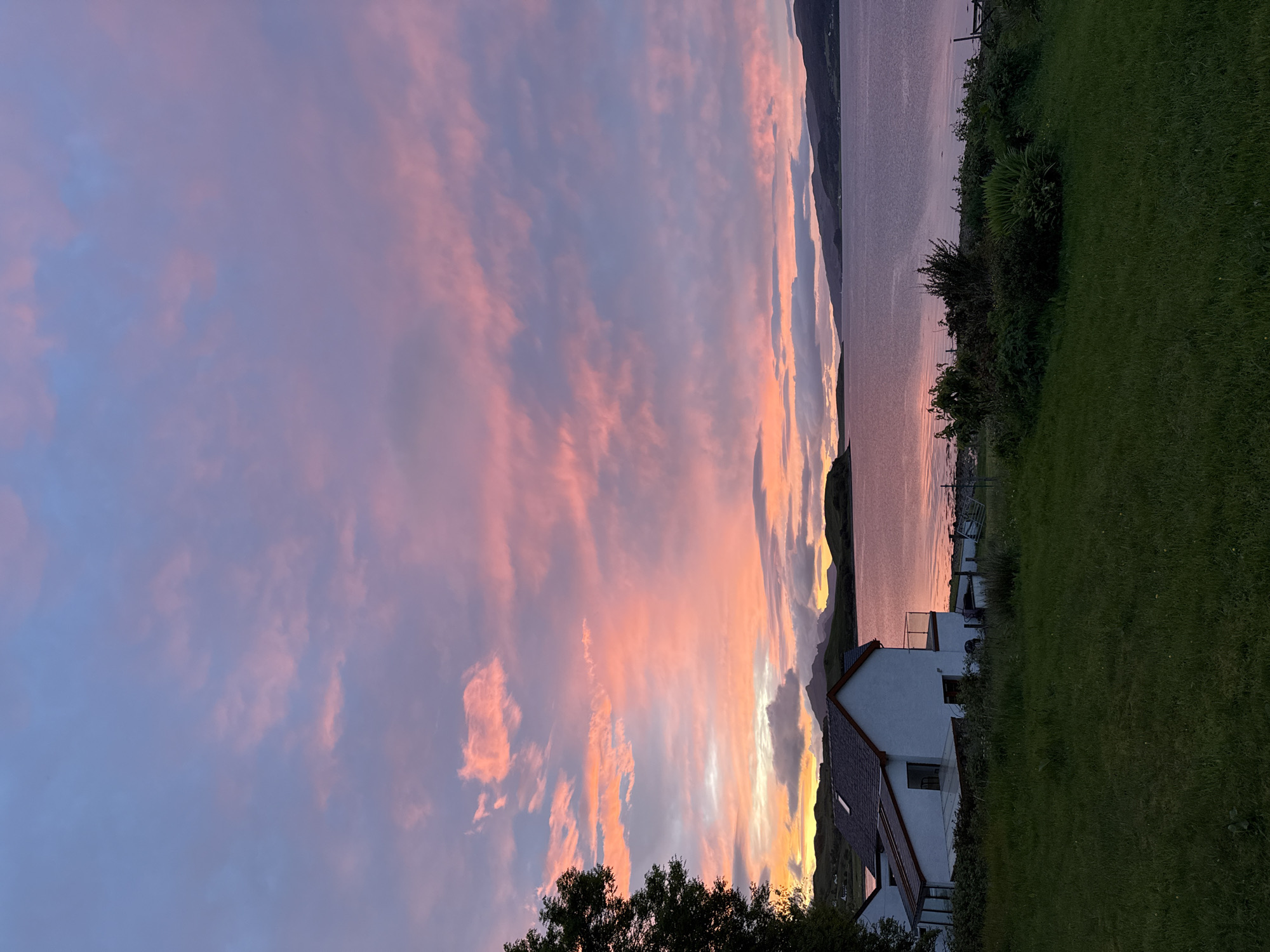 Vibrant sunset documented over Sconser coastline, white house featured
