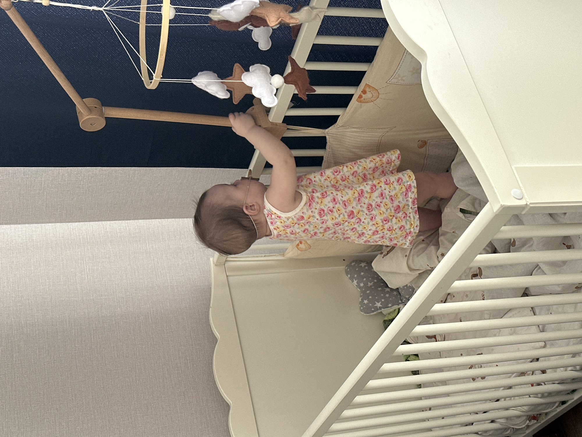 Baby reaches for mobile in crib in Подшивалово
