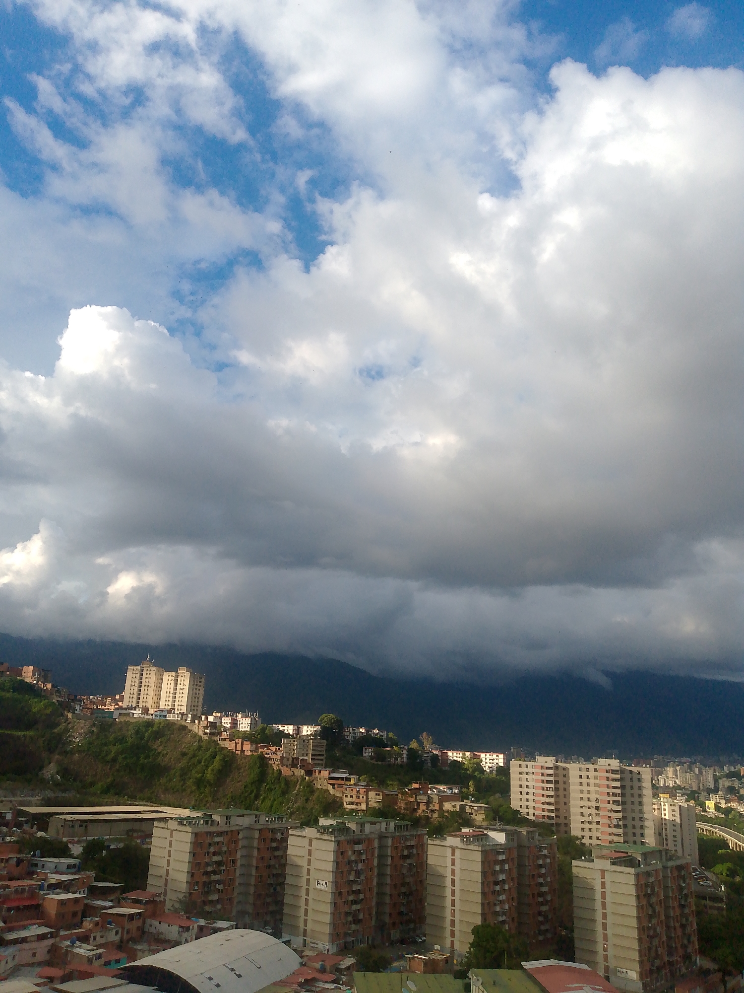 Caracas hillside neighborhoods under a dramatic overcast sky