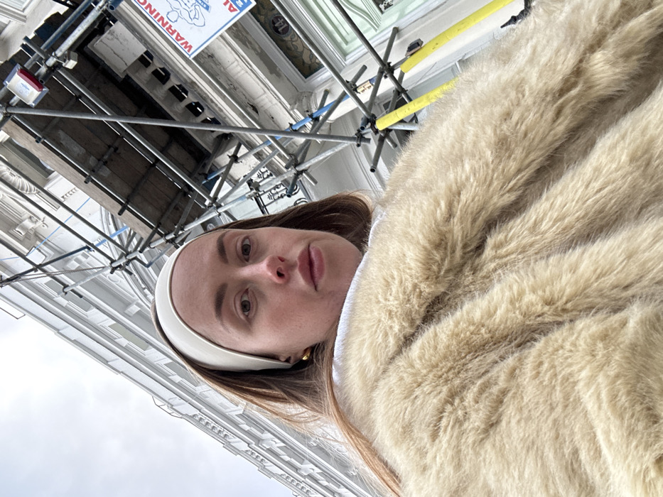Person in fur coat photographed walking London residential street