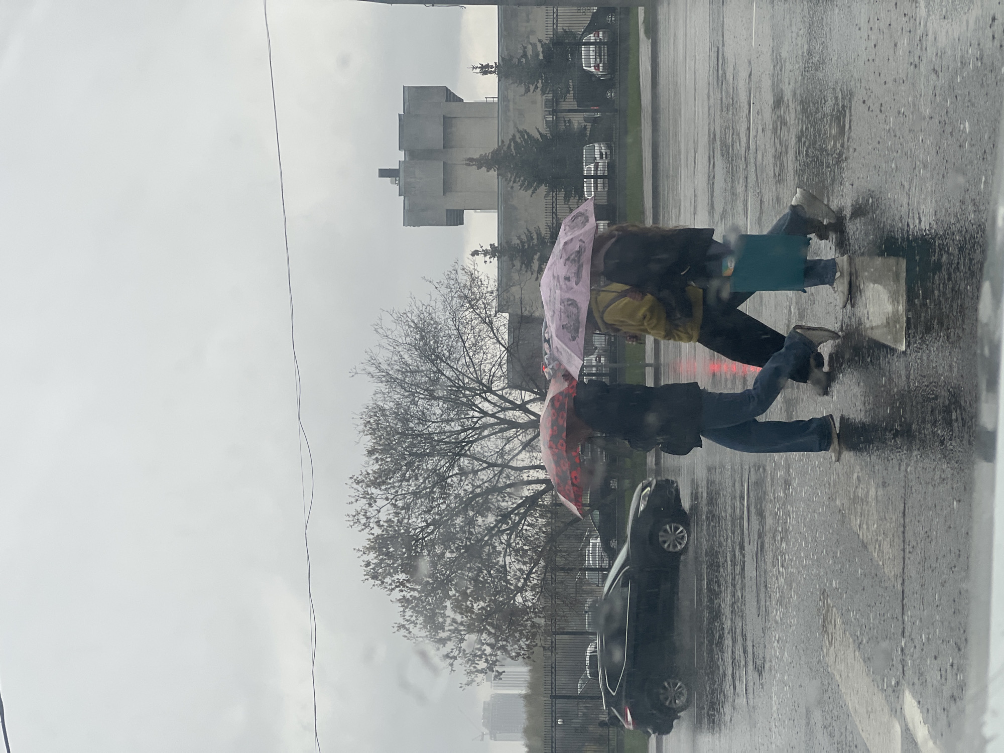 Two pedestrians cross Moscow street during morning rain